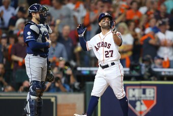 HOUSTON, TEXAS - OCTOBER 10:  Jose Altuve #27 of the Houston Astros hits a solo home run against the Tampa Bay Rays during the eighth inning in game five of the American League Division Series at Minute Maid Park on October 10, 2019 in Houston, Texas. (Ph