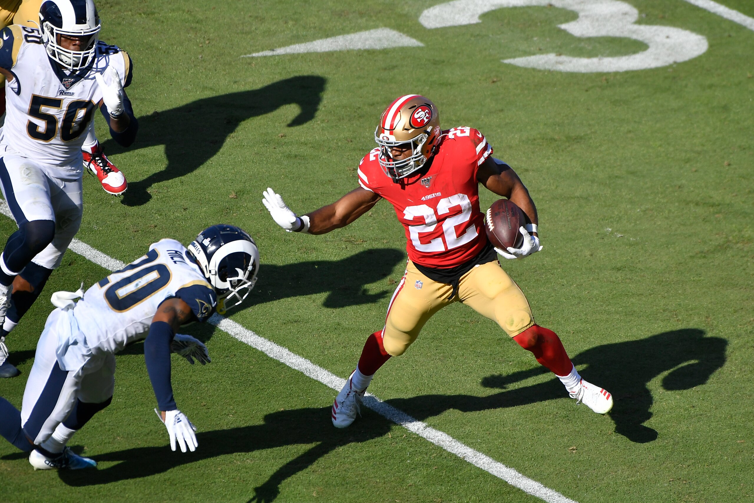 LOS ANGELES, CA - OCTOBER 13:  Matt Breida #22 of the San Francisco 49ers runs the ball against Troy Hill #20 and Samson Ebukam #50 of the Los Angeles Rams in the third quarter at Los Angeles Memorial Coliseum on October 13, 2019 in Los Angeles, Californi