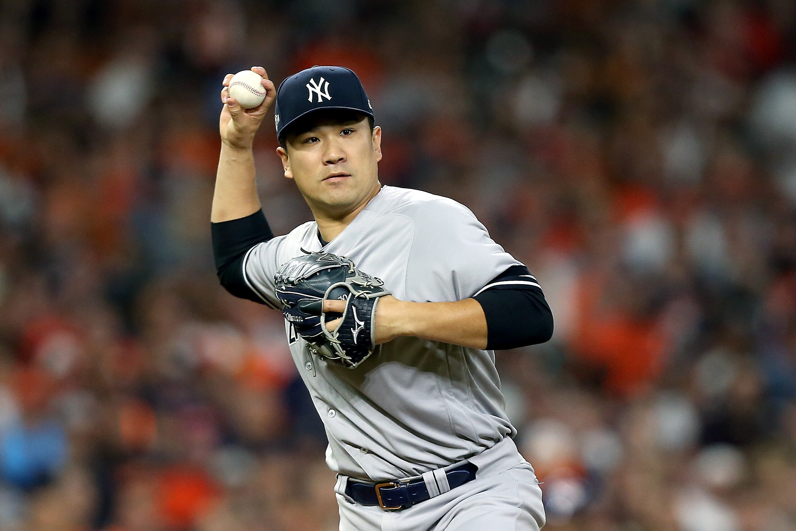 HOUSTON, TEXAS - OCTOBER 12:  Masahiro Tanaka #19 of the New York Yankees throws out the runner at first base to against the Houston Astros during the sixth inning in game one of the American League Championship Series at Minute Maid Park on October 12, 2