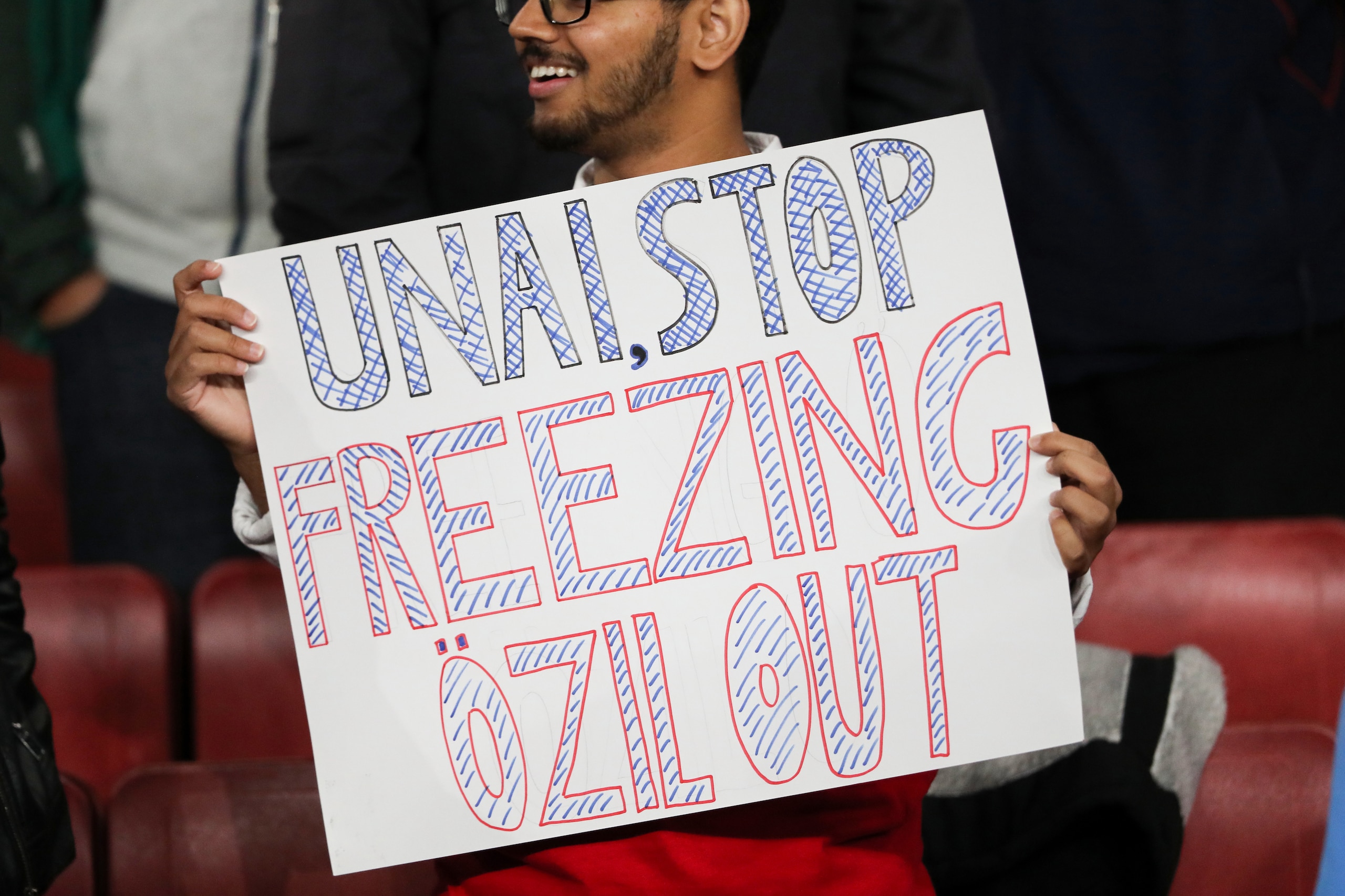 LONDON, ENGLAND - OCTOBER 24: A fan holding up a sign which says Unai Stop freezing ozil out during the UEFA Europa League group F match between Arsenal FC and Vitoria Guimaraes at Emirates Stadium on October 24, 2019 in London, United Kingdom. (Photo by 