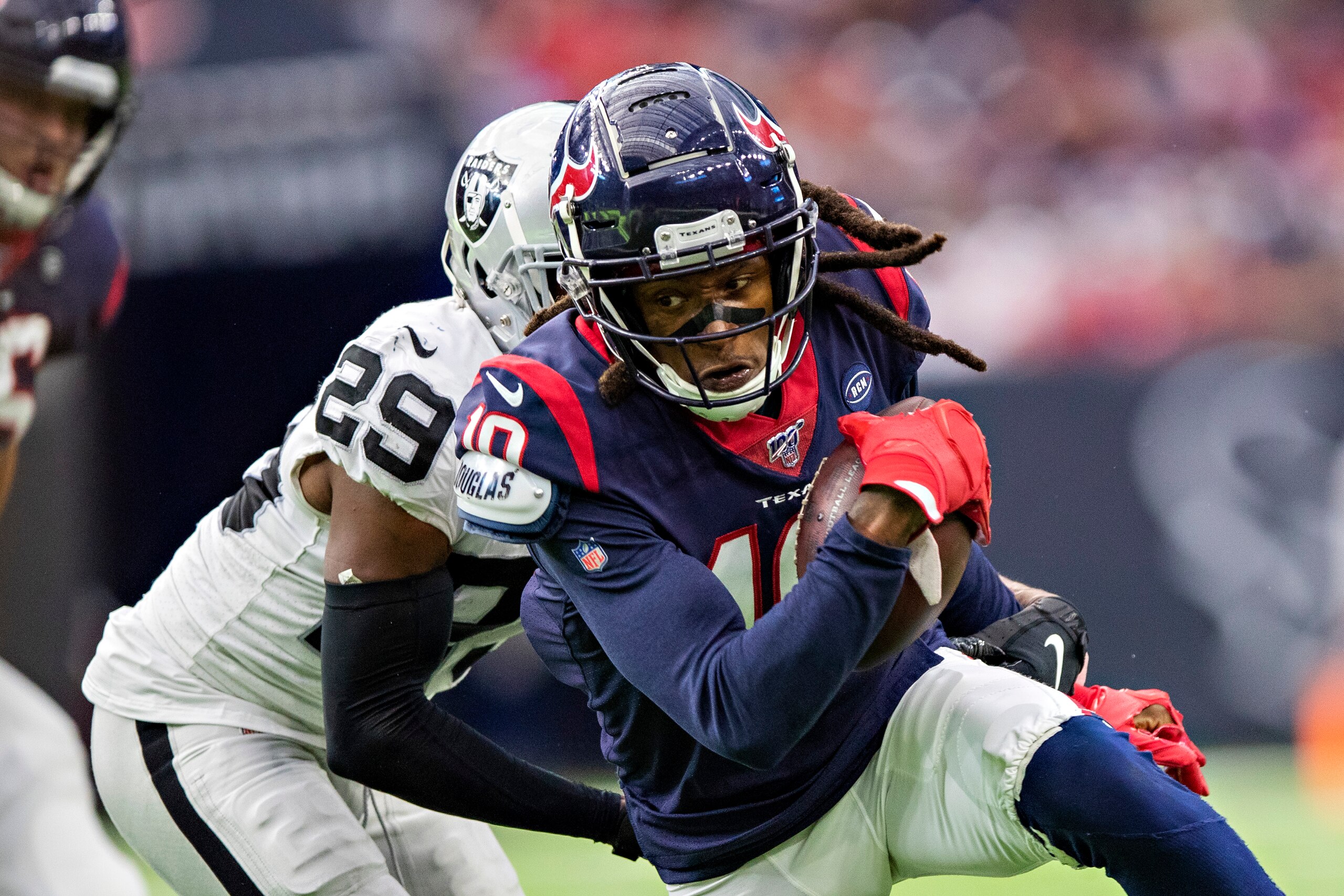 HOUSTON, TX - OCTOBER 27:  DeAndre Hopkins #10 of the Houston Texans catches a pass and is tackled from behind by Lamarcus Joyner #29 of the Oakland Raiders at NRG Stadium on October 27, 2019 in Houston, Texas.   (Photo by Wesley Hitt/Getty Images)