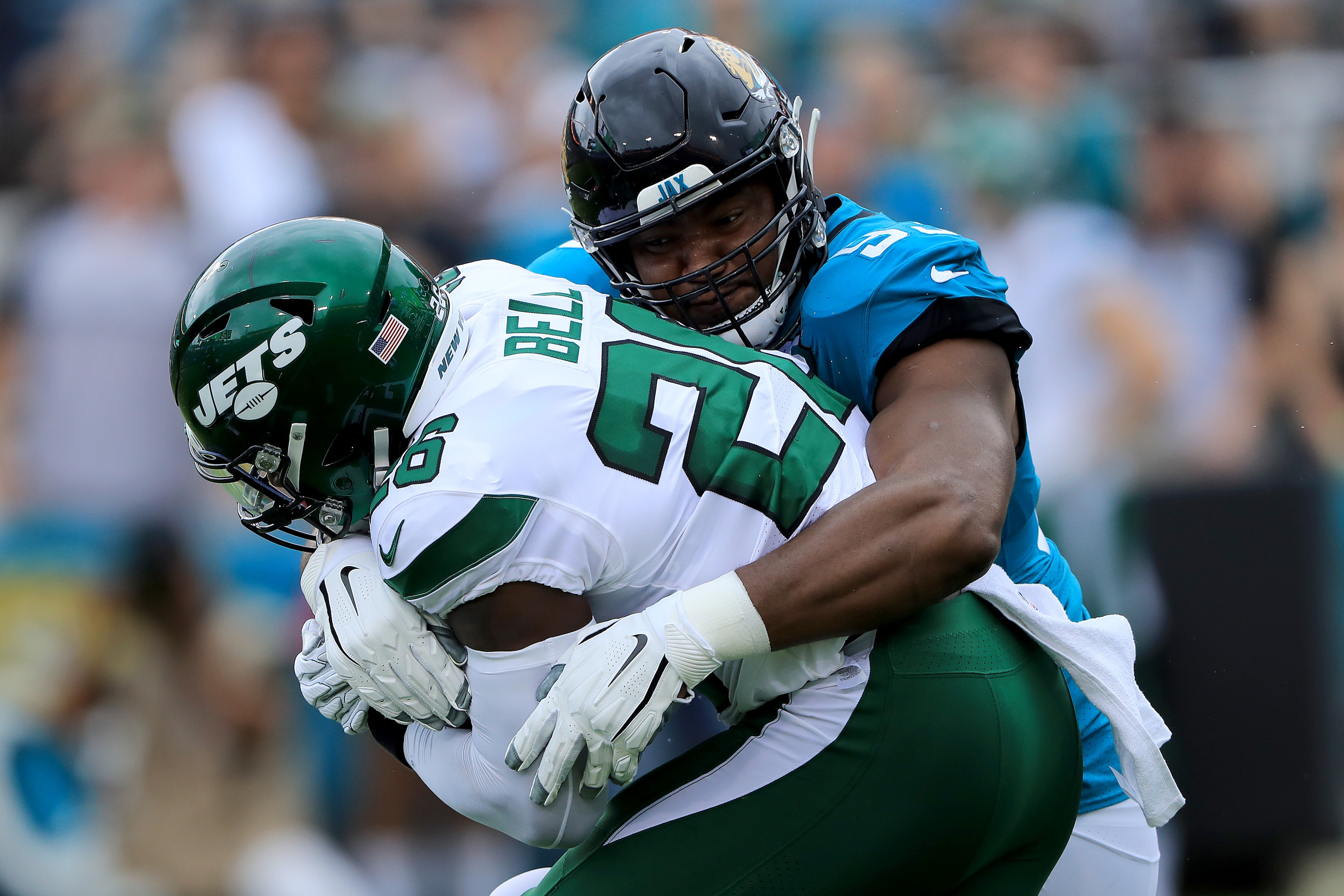 JACKSONVILLE, FLORIDA - OCTOBER 27: Calais Campbell #93 of the Jacksonville Jaguars tackles Le'Veon Bell #26 of the New York Jets during the game at TIAA Bank Field on October 27, 2019 in Jacksonville, Florida. (Photo by Sam Greenwood/Getty Images)