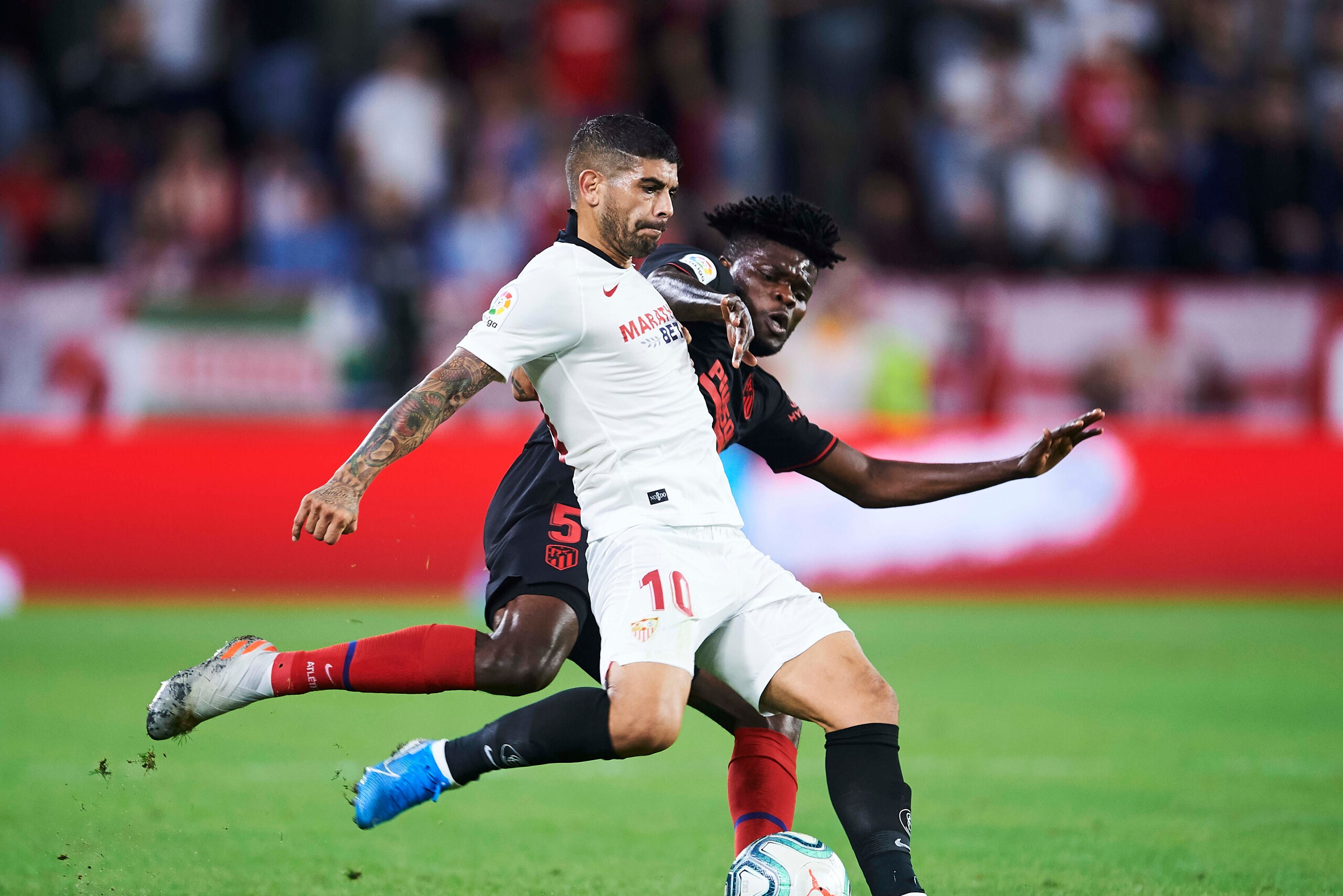 SEVILLE, SPAIN - NOVEMBER 02: Ever Banega of Sevilla FC (R) duels for the ball with Thomas Teye Partey of Club Atletico de Madrid (L) during the Liga match between Sevilla FC and Club Atletico de Madrid at Estadio Ramon Sanchez Pizjuan on November 02, 201