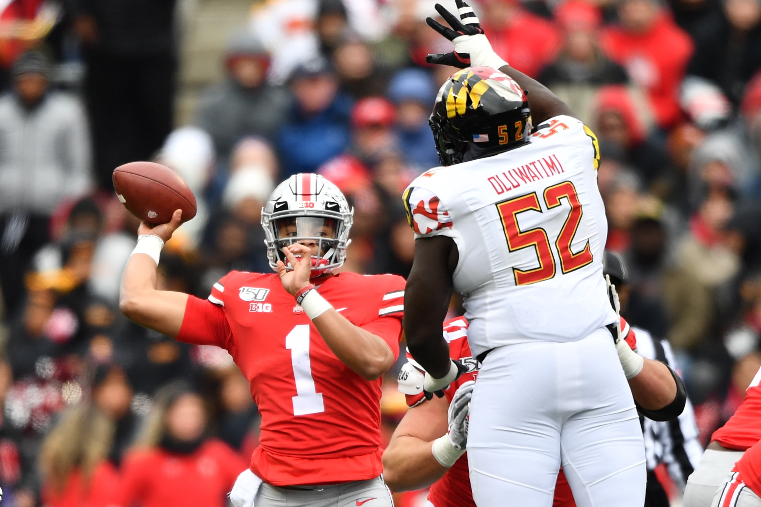 COLUMBUS, OH - NOVEMBER 9:  Quarterback Justin Fields #1 of the Ohio State Buckeyes passes over the defense of Oluwaseun Oluwatimi #52 of the Maryland Terrapins in the first quarter at Ohio Stadium on November 9, 2019 in Columbus, Ohio.  (Photo by Jamie S