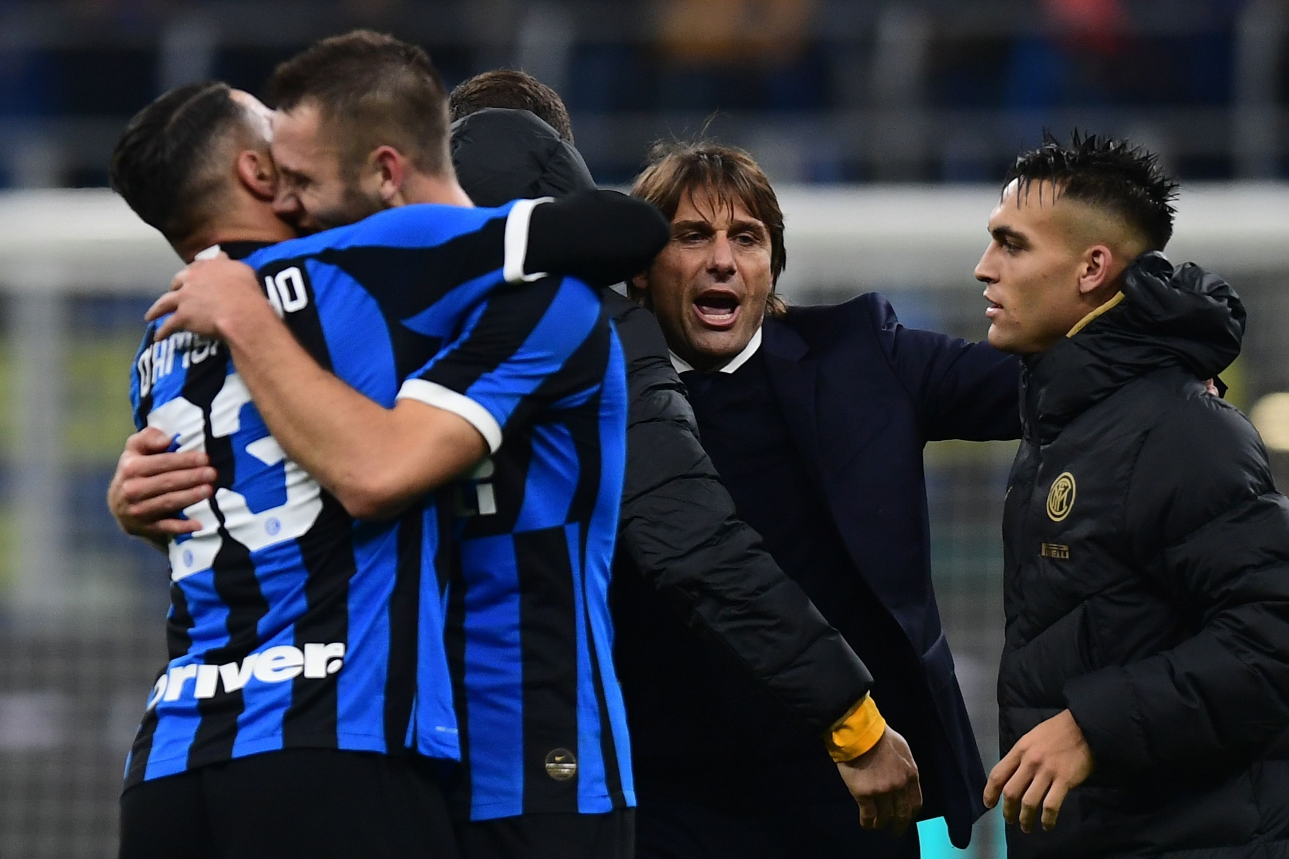 (From L) Inter Milan's Italian defender Danilo D'Ambrosio, Inter Milan's Croatian defender Marcelo Brozovic, Inter Milan's Italian head coach Antonio Conte and Inter Milan's Argentinian forward Lautaro Martinez celebrate at the end of the Italian Serie A 
