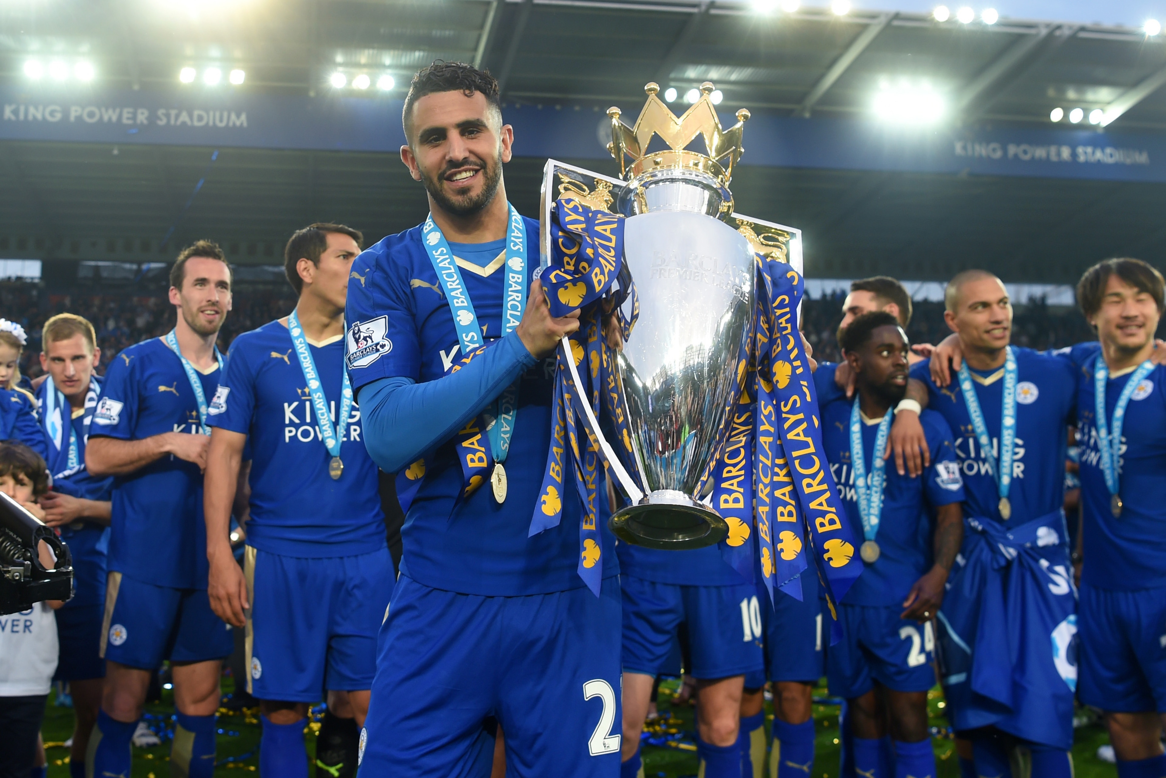 LEICESTER, ENGLAND - MAY 07:  Riyad Mahrez of Leicester City poses with the Premier League Trophy as players and staffs celebrate the season champion after the Barclays Premier League match between Leicester City and Everton at The King Power Stadium on M