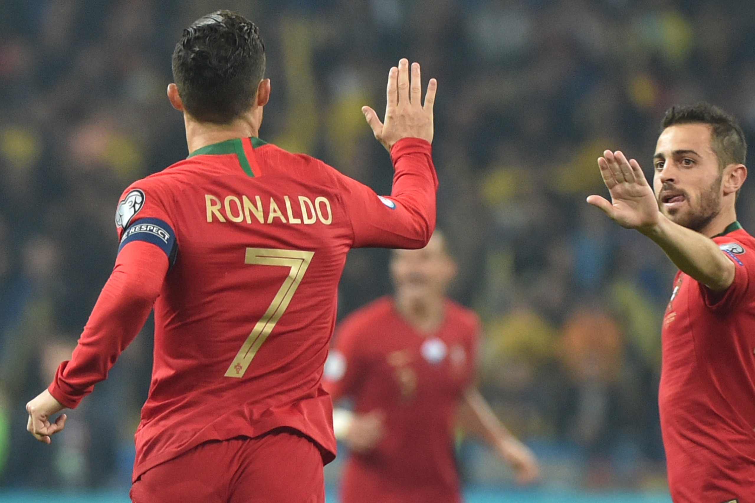 Portugal's forward Cristiano Ronaldo celebrates with Portugal's forward Bernardo Silva after scoring a goal from the penalty spot during the Euro 2020 football qualification match between Ukraine and Portugal at the NSK Olimpiyskyi stadium in Kiev on Octo Portugal's forward Cristiano Ronaldo celebrates with Portugal's forward Bernardo Silva after scoring a goal from the penalty spot during the Euro 2020 football qualification match between Ukraine and Portugal at the NSK Olimpiyskyi stadium in Kiev on Octo
