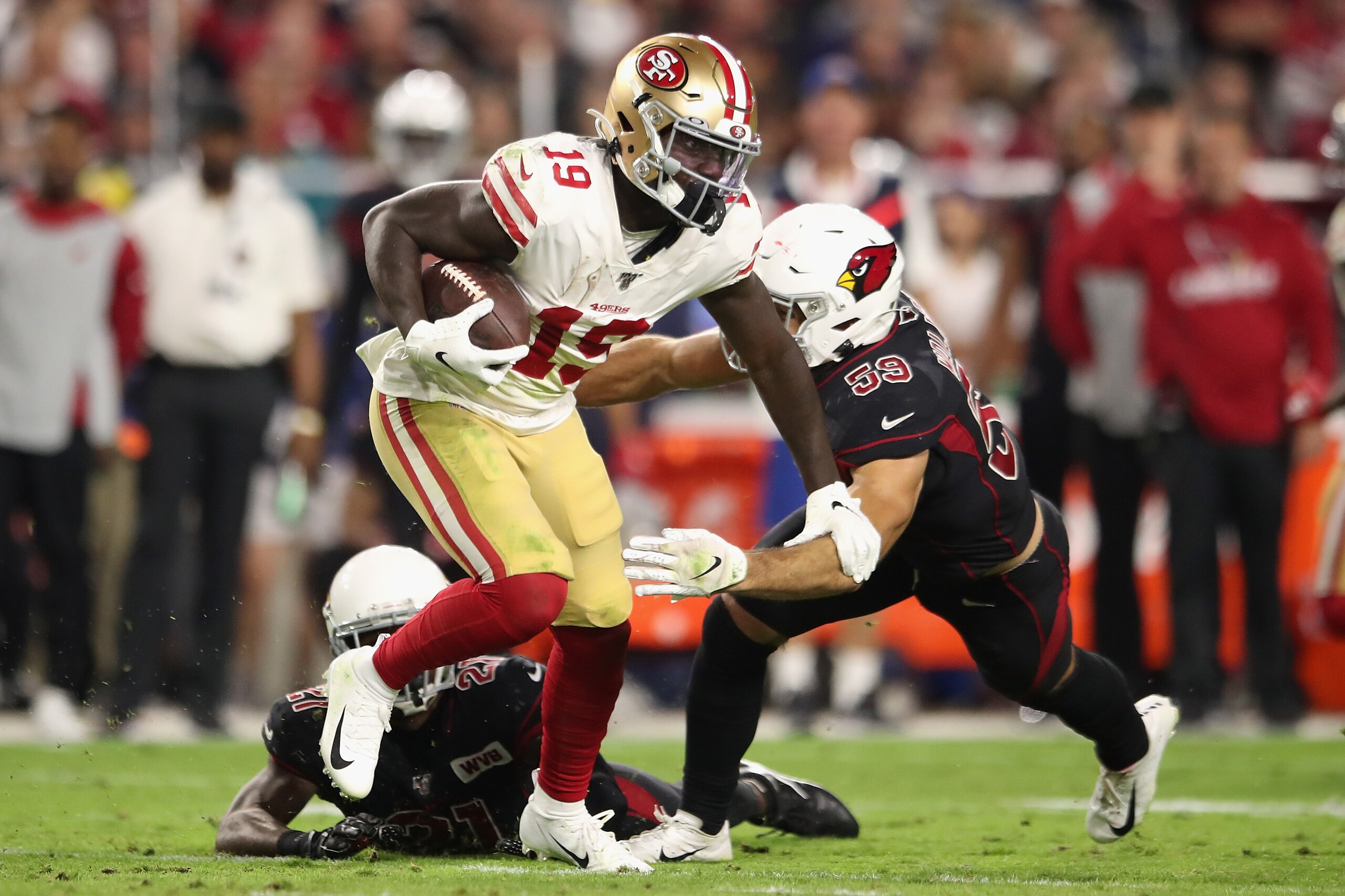 GLENDALE, ARIZONA - OCTOBER 31: Wide receiver Deebo Samuel #19 of the San Francisco 49ers runs with the football against linebacker Joe Walker #59 of the Arizona Cardinals during the second half of the NFL game at State Farm Stadium on October 31, 2019 in