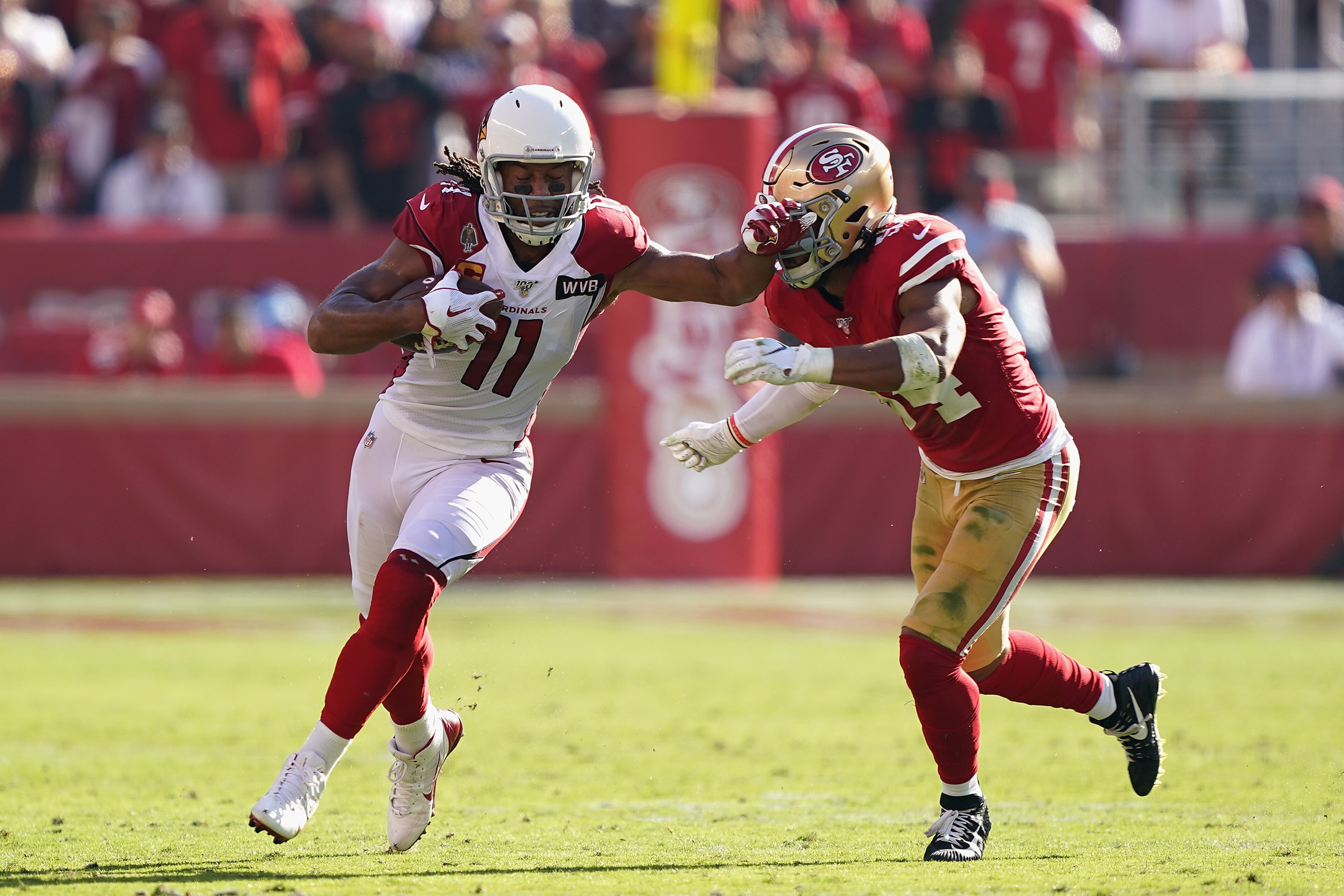 SANTA CLARA, CALIFORNIA - NOVEMBER 17: Wide receiver Larry Fitzgerald #11 of the Arizona Cardinals runs with the football after a reception past linebacker Fred Warner #54 of the San Francisco 49ers during the first half of the NFL game at Levi's Stadium 