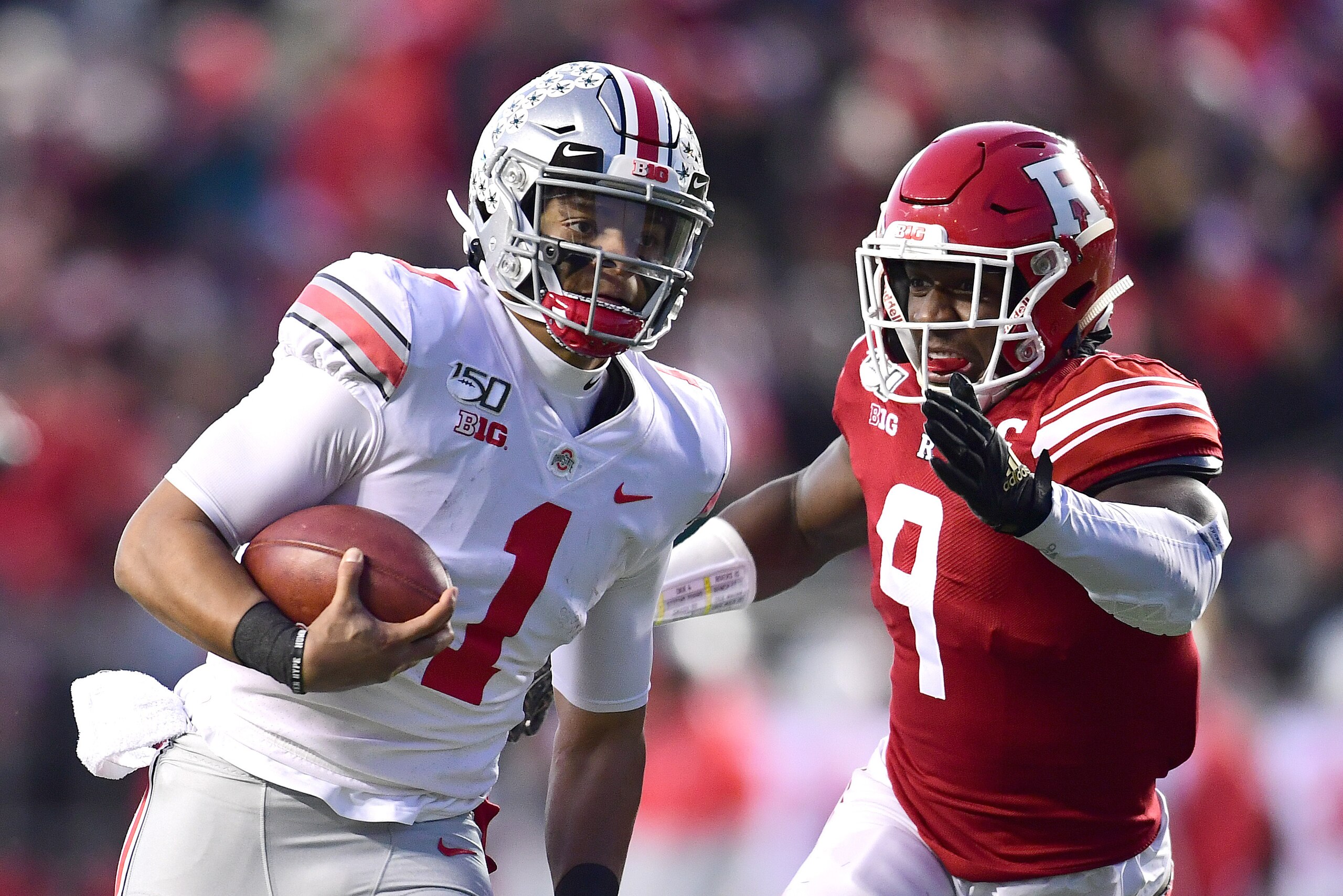 PISCATAWAY, NEW JERSEY - NOVEMBER 16: Justin Fields #1 of the Ohio State Buckeyes runs the ball past Tyreek Maddox-Williams #9 of the Rutgers Scarlet Knights during the first half of their game at SHI Stadium on November 16, 2019 in Piscataway, New Jersey PISCATAWAY, NEW JERSEY - NOVEMBER 16: Justin Fields #1 of the Ohio State Buckeyes runs the ball past Tyreek Maddox-Williams #9 of the Rutgers Scarlet Knights during the first half of their game at SHI Stadium on November 16, 2019 in Piscataway, New Jersey