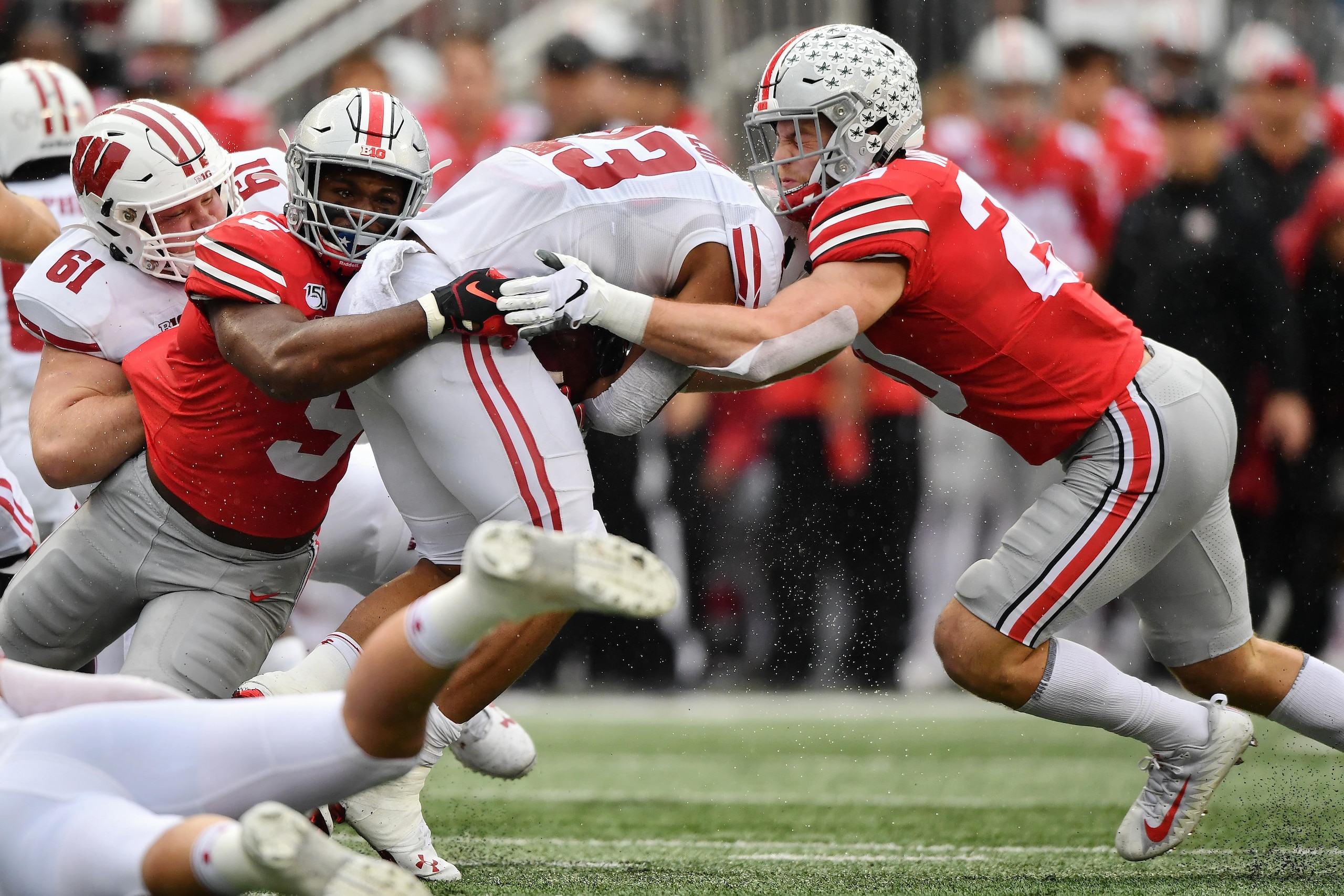 COLUMBUS, OH - OCTOBER 26:  Baron Browning #5 of the Ohio State Buckeyes and Pete Werner #20 of the Ohio State Buckeyes tackle Jonathan Taylor #23 of the Wisconsin Badgers at Ohio Stadium on October 26, 2019 in Columbus, Ohio.  (Photo by Jamie Sabau/Getty