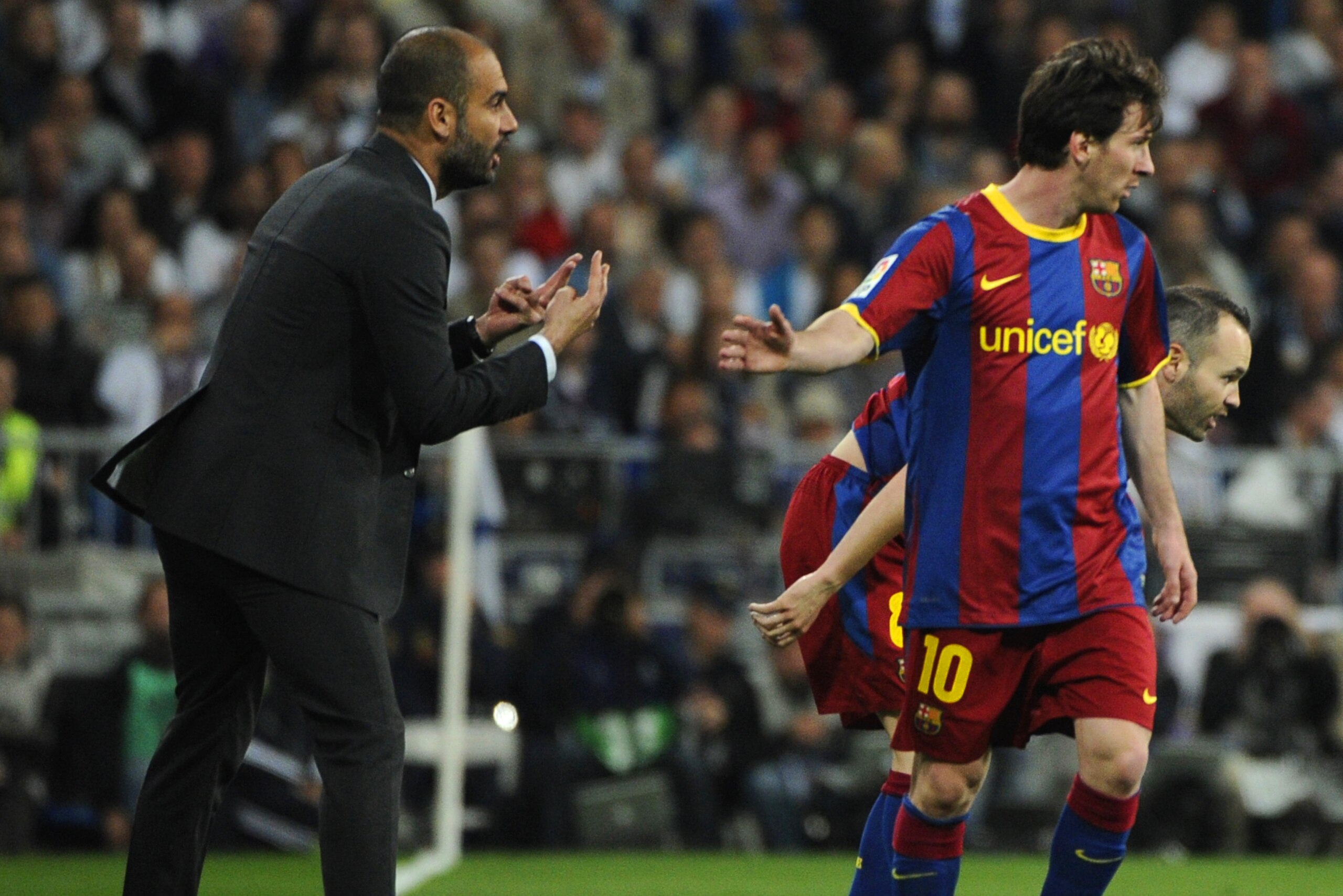 Barcelona's coach Josep Guardiola (L) speaks with Barcelona's Argentinian forward Lionel Messi (R) during