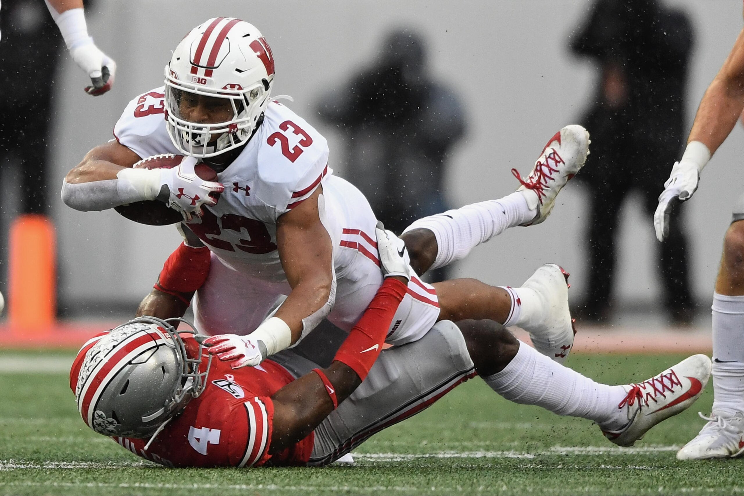 COLUMBUS, OH - OCTOBER 26:  Jonathan Taylor #23 of the Wisconsin Badgers is brought down by Jordan Fuller #4 of the Ohio State Buckeyes after picking up a first down in the first quarter at Ohio Stadium on October 26, 2019 in Columbus, Ohio.  (Photo by Ja