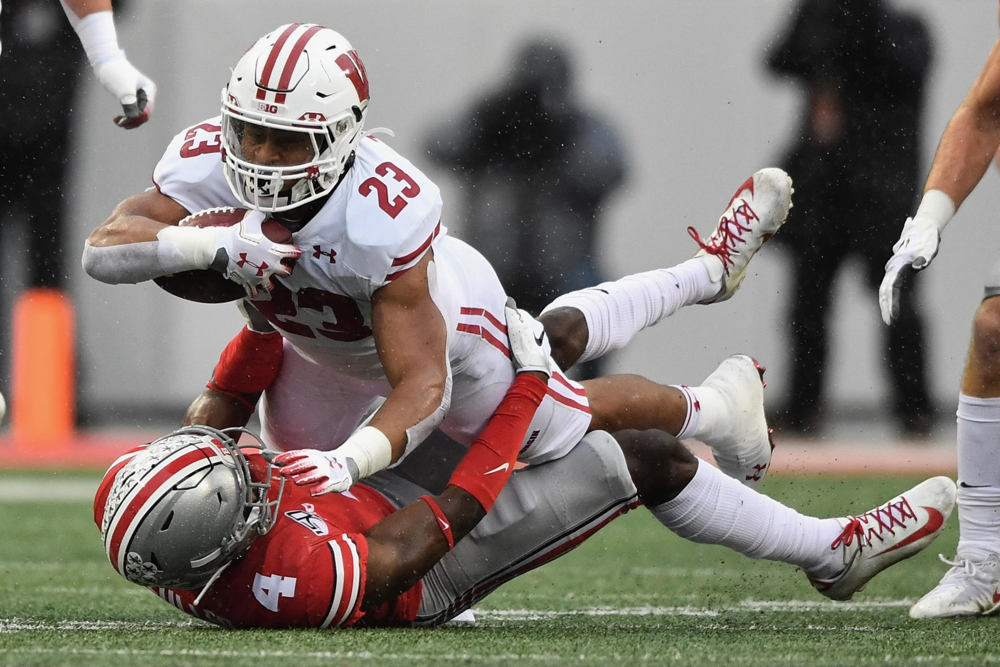 COLUMBUS, OH - OCTOBER 26:  Jonathan Taylor #23 of the Wisconsin Badgers is brought down by Jordan Fuller #4 of the Ohio State Buckeyes after picking up a first down in the first quarter at Ohio Stadium on October 26, 2019 in Columbus, Ohio.  (Photo by Ja