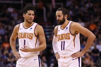 PHOENIX, ARIZONA - OCTOBER 28: Devin Booker #1 of the Phoenix Suns talks with Ricky Rubio #11 during the second half of the NBA game against the Utah Jazz at Talking Stick Resort Arena on October 28, 2019 in Phoenix, Arizona. The Jazz defeated the Suns 96