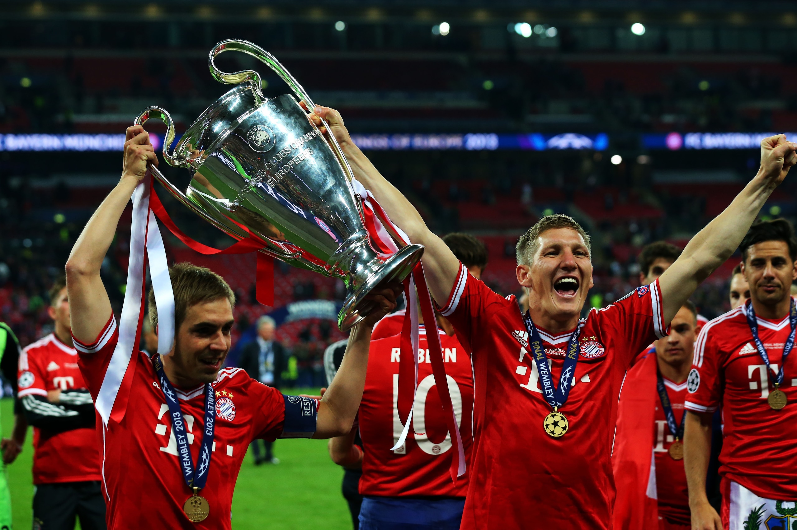 LONDON, ENGLAND - MAY 25:  Philipp Lahm and Bastian Schweinsteiger of Bayern Muenchen hold the trophy after winning the UEFA Champions League final match against Borussia Dortmund at Wembley Stadium on May 25, 2013 in London, United Kingdom.  (Photo by Al
