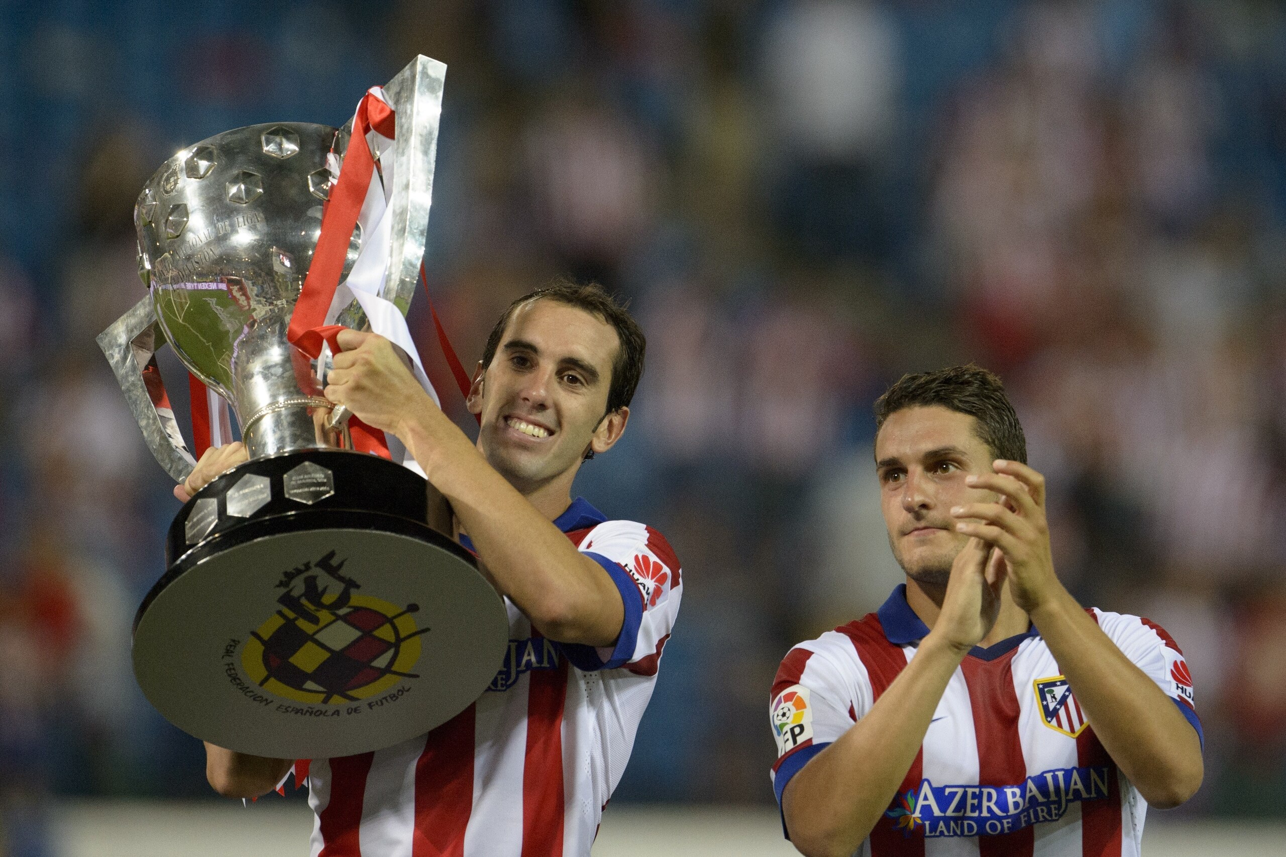 Atletico Madrid's Uruguayan defender Diego Godin carries the 2013-2014 Spanish Liga Champions trophy before the Spanish league football match Club Atletico de Madrid vs S.D Eibar at the Vicente Calderon stadium in Madrid on August 30, 2014.   AFP PHOTO/ D