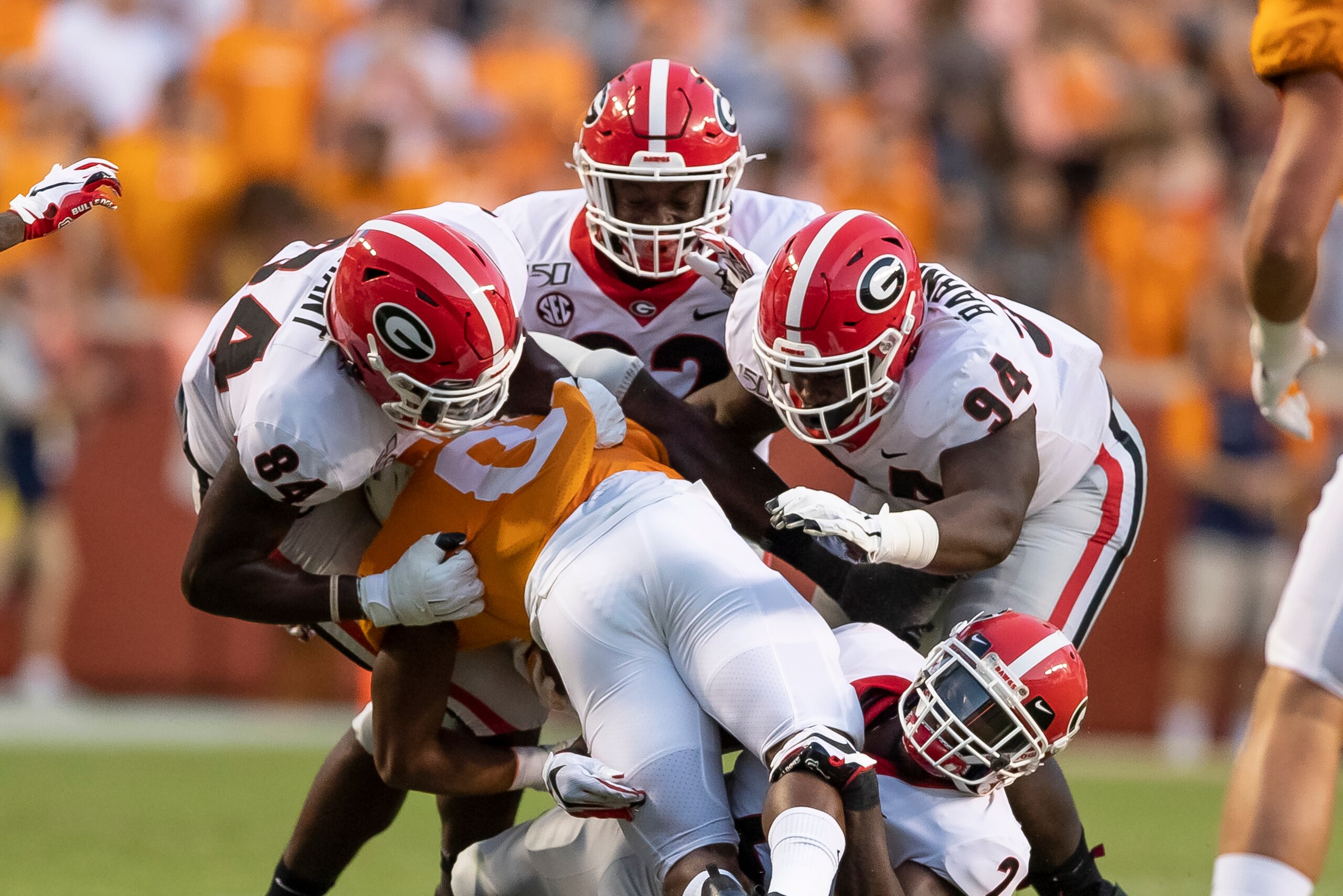 KNOXVILLE, TN - OCTOBER 05: Walter Grant #84, Michael Barnett #94 and Monty Rice #32 of the Georgia Bulldogs gang tackle Ty Chandler #8 of the Tennessee Volunteers during a game between University of Georgia Bulldogs and University of Tennessee Volunteers