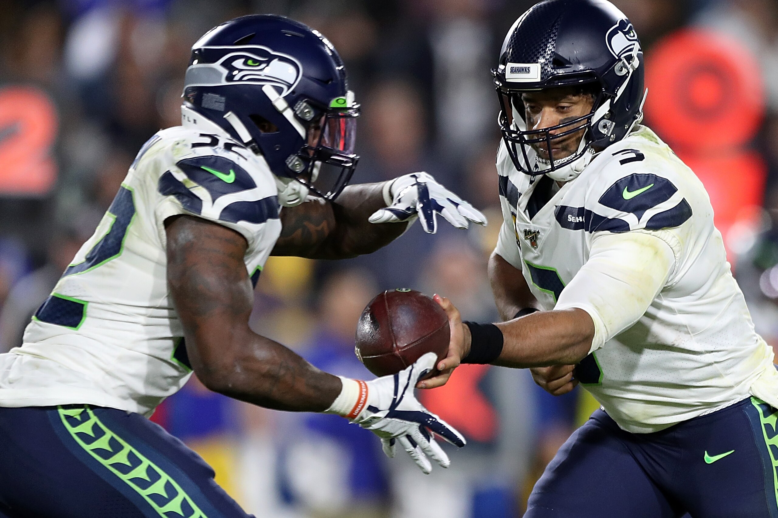 LOS ANGELES, CALIFORNIA - DECEMBER 08: Quarterback Russell Wilson #3 of the Seattle Seahawks  hands off to running back Chris Carson #32 during the game against the Los Angeles Rams at Los Angeles Memorial Coliseum on December 08, 2019 in Los Angeles, Cal