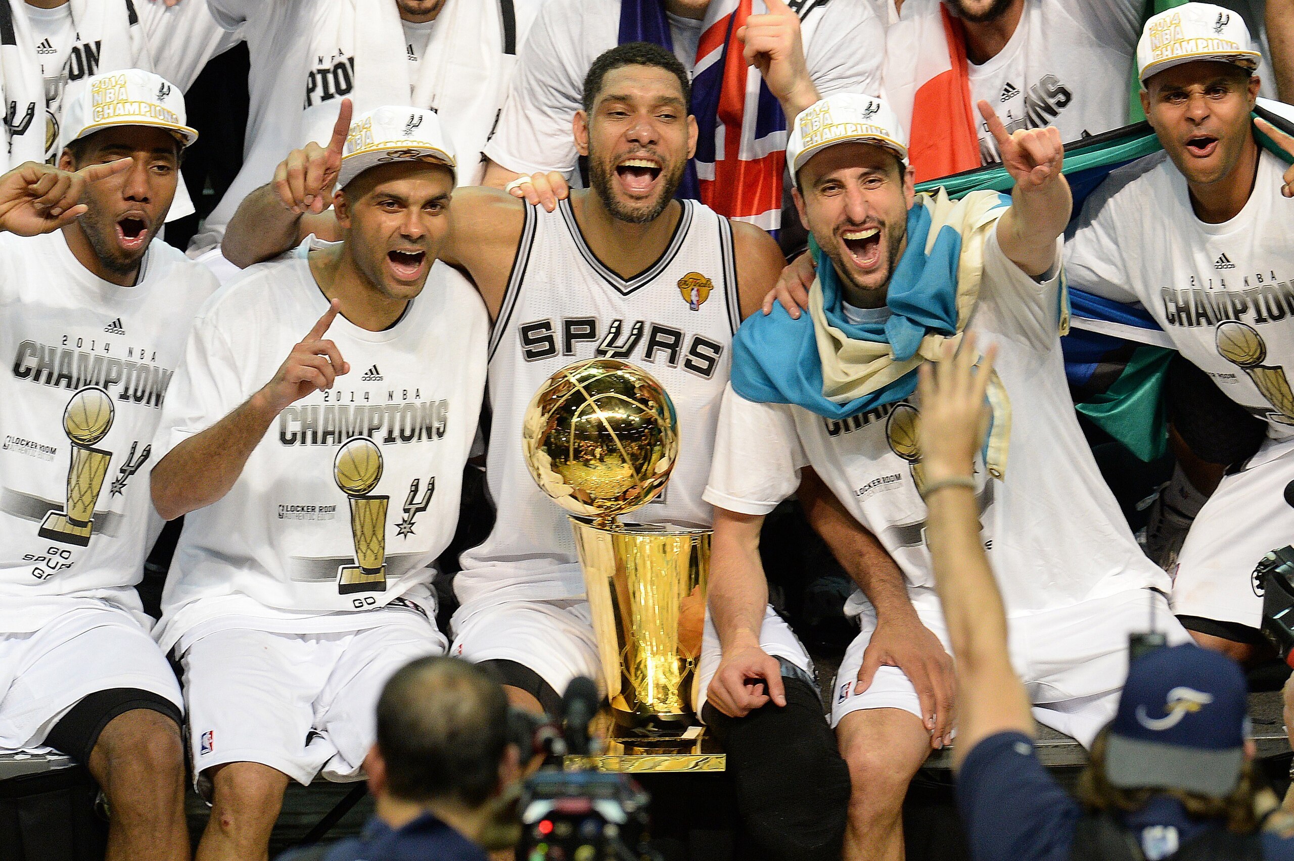 The San Antonio Spurs celebrate with the Larry O'Brien NBA Championship Trophy after the Spurs defeated the Miami Heat 107-84 in Game 5 of the NBA Finals to win the NBA Finals Championship, June 15, 2014 in San Antonio,Texas.  From left are: MVP Kawhi Leo
