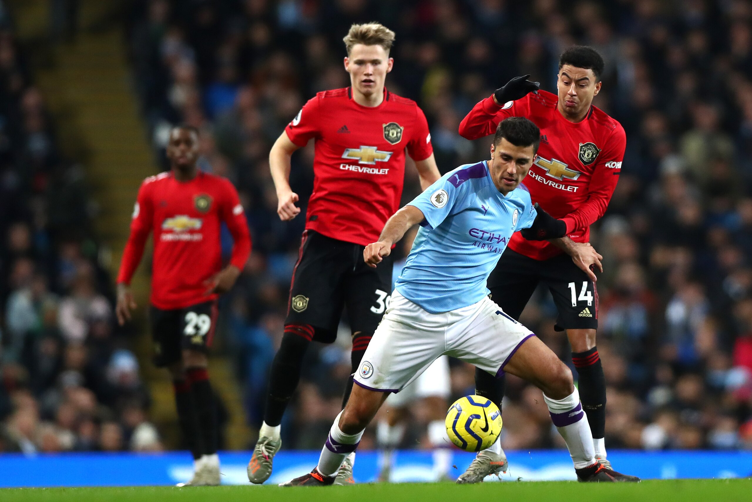 MANCHESTER, ENGLAND - DECEMBER 07: Rodrigo of Manchester City and Jesse Lingard and Scott Mctominay of Manchester United in action   during the Premier League match between Manchester City and Manchester United at Etihad Stadium on December 07, 2019 in Ma