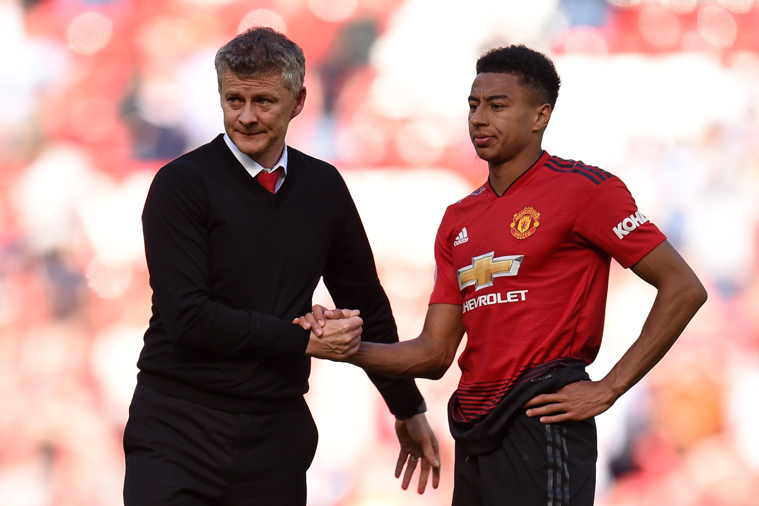 Manchester United's English midfielder Jesse Lingard (R) shakes hands with Manchester United's Norwegian manager Ole Gunnar Solskjaer (L) on the pitch after  the English Premier League football match between Manchester United and Cardiff City at Old Traff