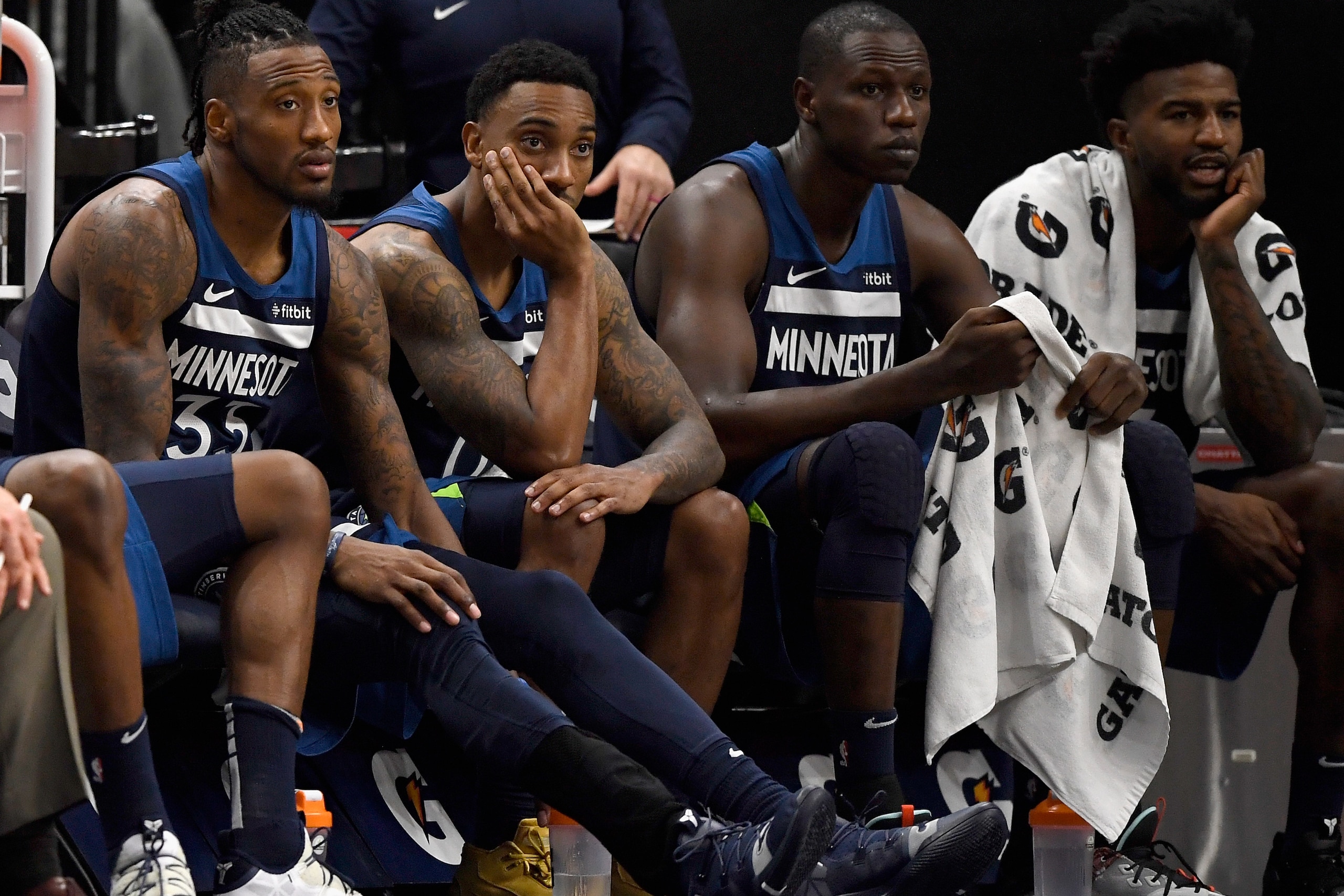 MINNEAPOLIS, MINNESOTA - NOVEMBER 04: (L-R) Robert Covington #33, Jeff Teague #0, Gorgui Dieng #5 and Jordan Bell #7 of the Minnesota Timberwolves look on from the bench in the final minutes of the game against the Milwaukee Bucks at Target Center on Nove
