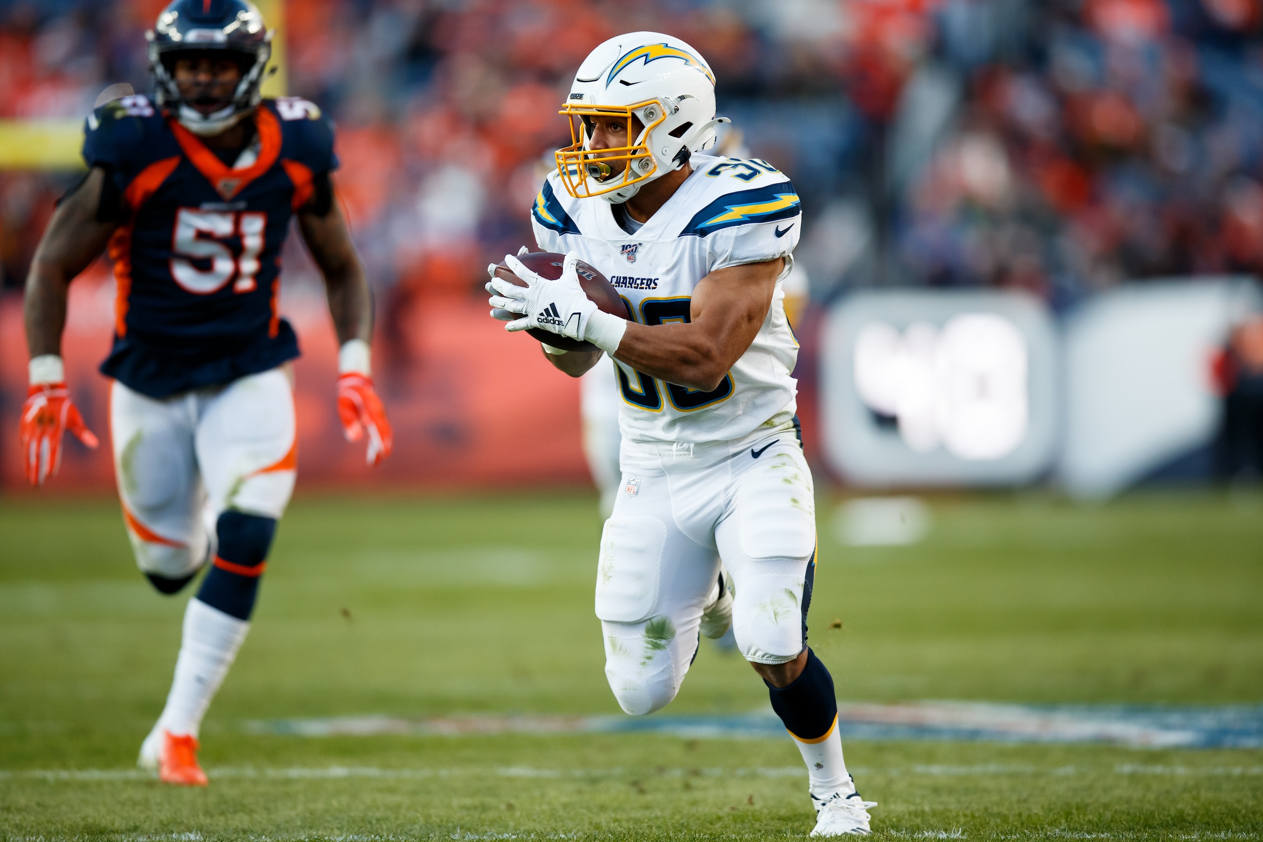 DENVER, CO - DECEMBER 1: Running back Austin Ekeler #30 of the Los Angeles Chargers runs for a touchdown after a pass reception as linebacker Todd Davis #51 of the Denver Broncos gives chase during the second quarter at Empower Field at Mile High on Dece DENVER, CO - DECEMBER 1: Running back Austin Ekeler #30 of the Los Angeles Chargers runs for a touchdown after a pass reception as linebacker Todd Davis #51 of the Denver Broncos gives chase during the second quarter at Empower Field at Mile High on Dece
