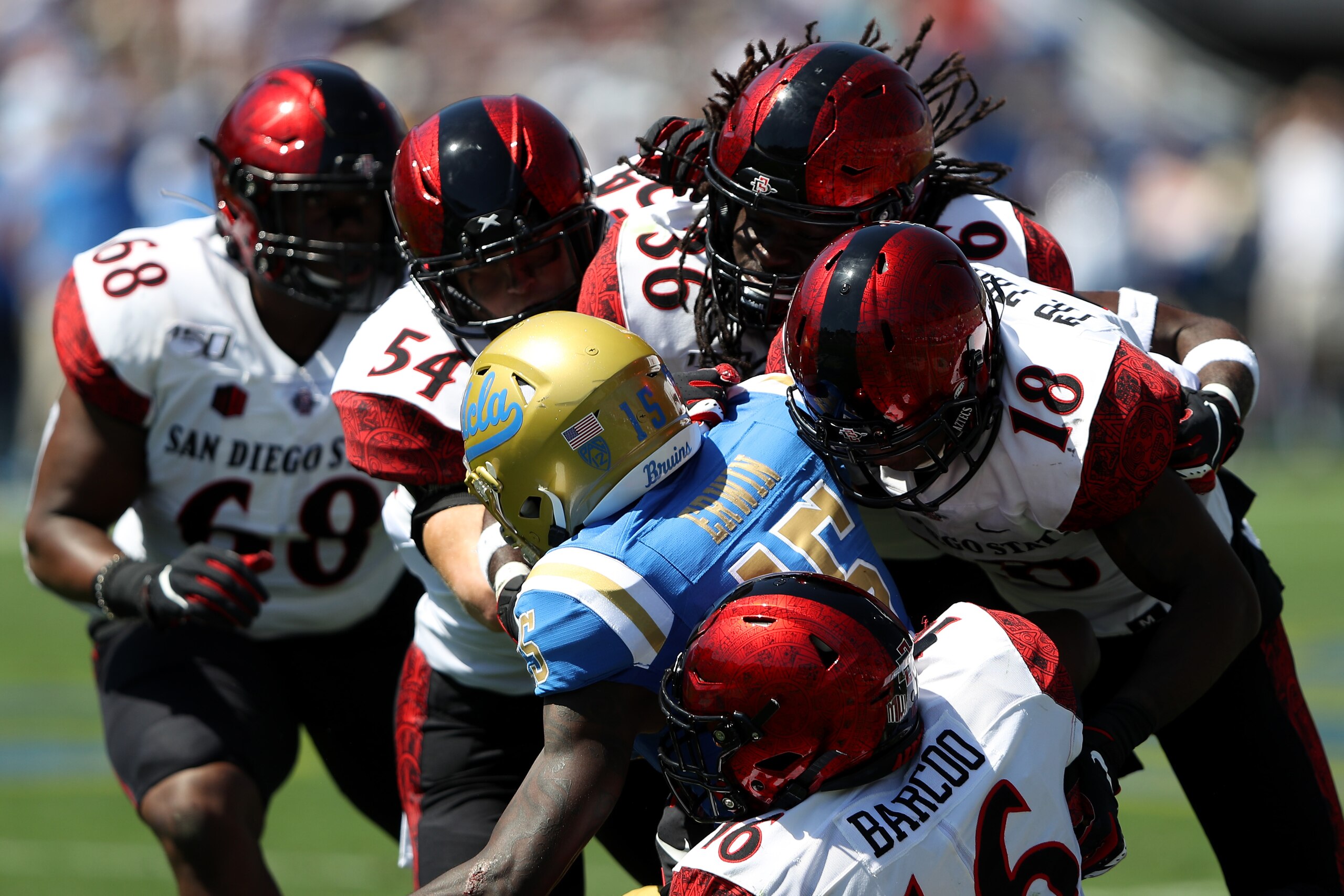 LOS ANGELES, CALIFORNIA - SEPTEMBER 07:  Jaylen Erwin #15 of the UCLA Bruins is tackled by Trenton Thompson #18, Luq Barcoo #16, Dwayne Johnson Jr. #36, and Caden McDonald #54 during the first half of a game on September 07, 2019 in Los Angeles, Californi