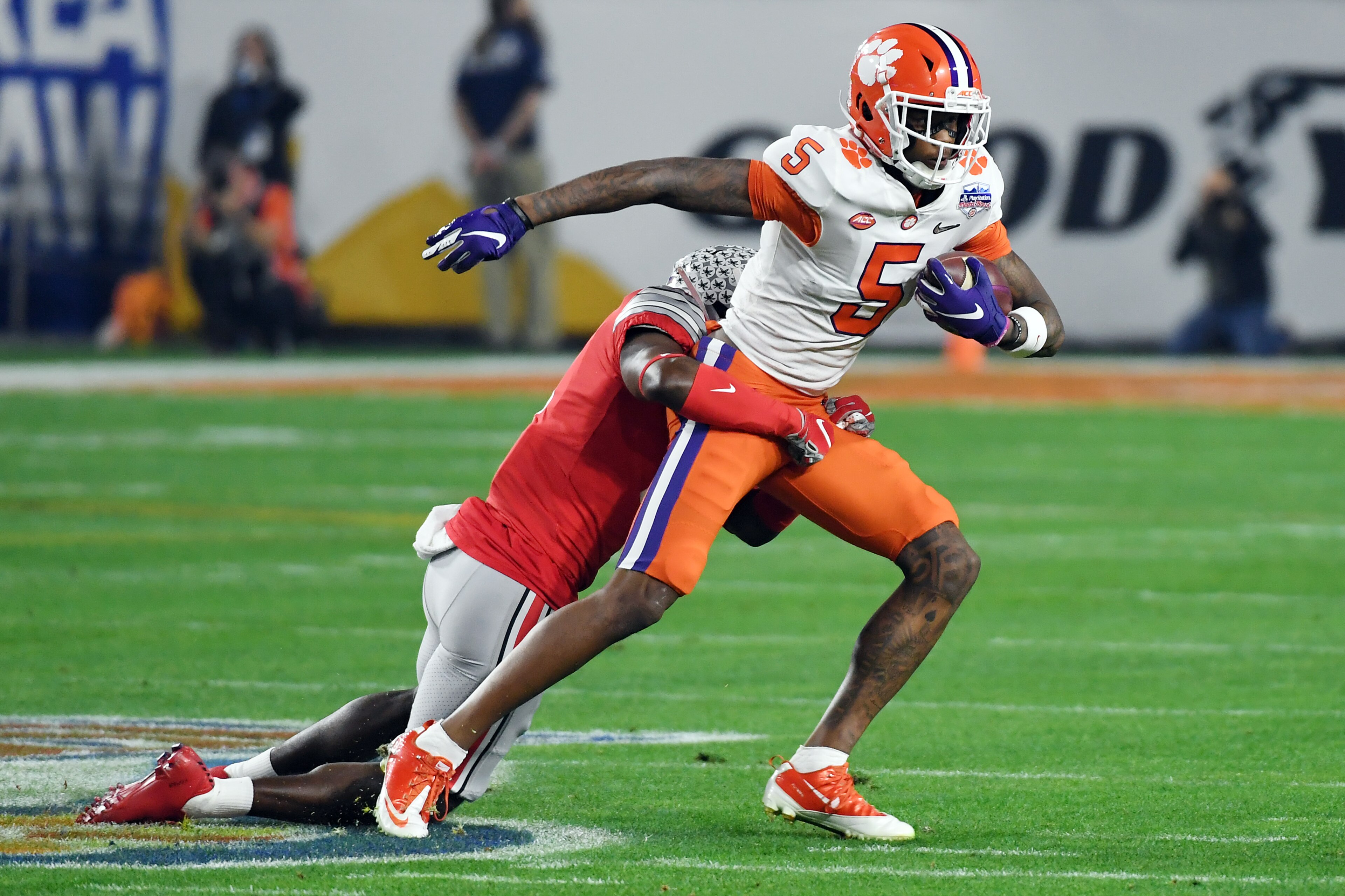 GLENDALE, ARIZONA - DECEMBER 28:  Tee Higgins #5 of the Clemson Tigers is tackled by Jordan Fuller #4 of the Ohio State Buckeyes in the first half during the College Football Playoff Semifinal at the PlayStation Fiesta Bowl at State Farm Stadium on Decemb