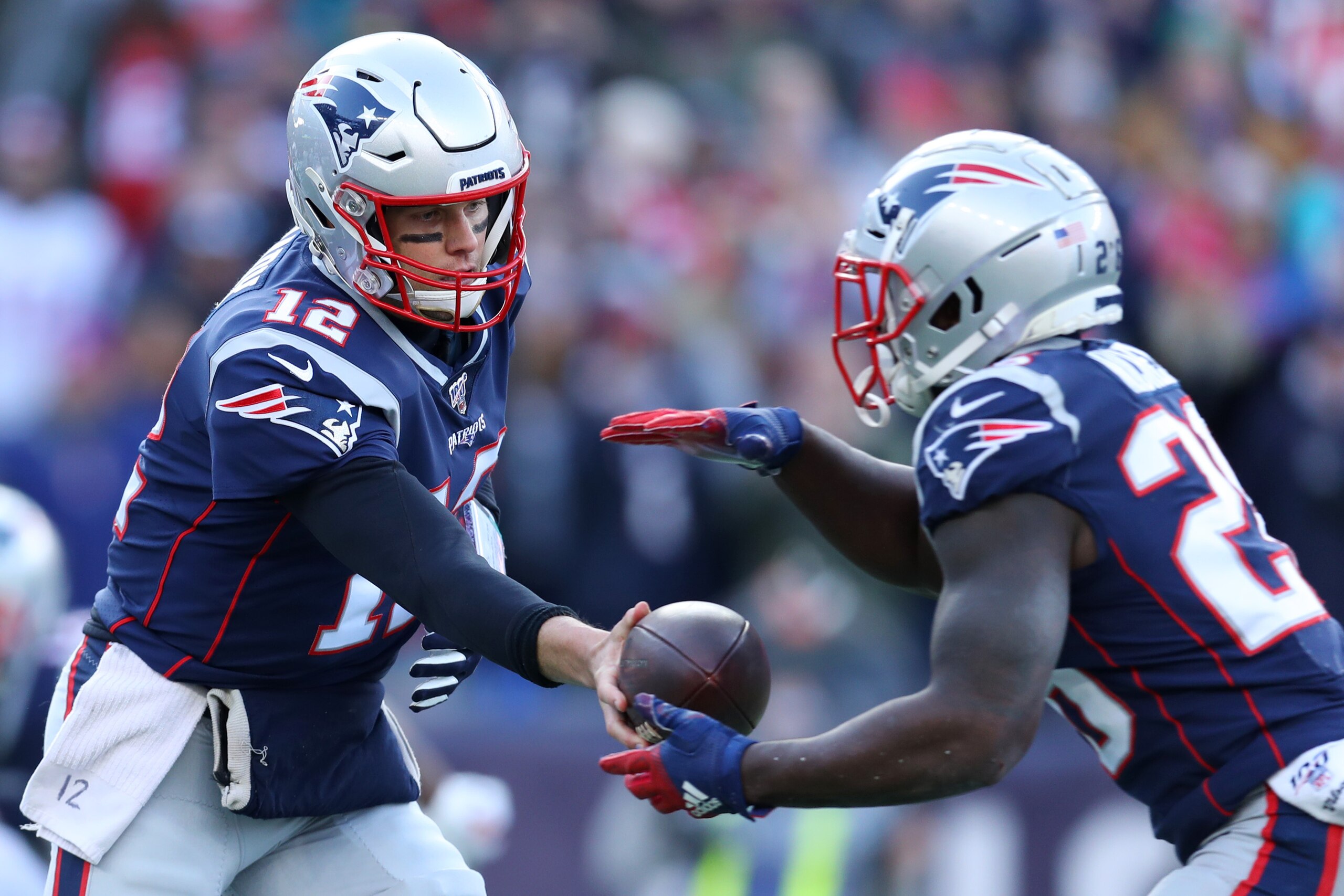 FOXBOROUGH, MASSACHUSETTS - DECEMBER 29: Tom Brady #12 of the New England Patriots hands the ball off to Sony Michel #26 during the game against the Miami Dolphins  at Gillette Stadium on December 29, 2019 in Foxborough, Massachusetts. (Photo by Maddie Me