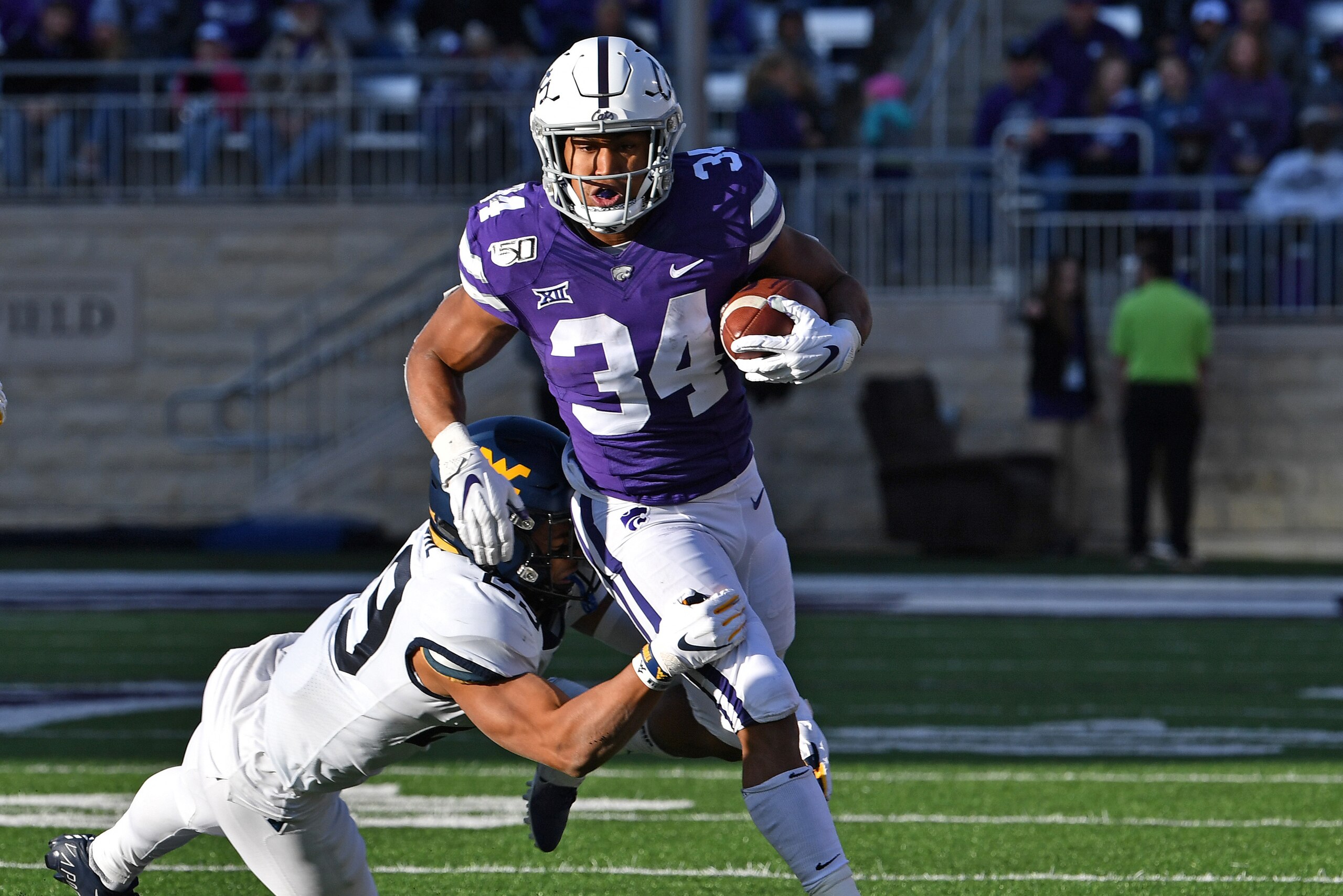 MANHATTAN, KS - NOVEMBER 16: Running back James Gilbert #34 of the Kansas State Wildcats runs up field against safety Sean Mahone #29 of the West Virginia Mountaineers during the first half at Bill Snyder Family Football Stadium on November 16, 2019 in M MANHATTAN, KS - NOVEMBER 16: Running back James Gilbert #34 of the Kansas State Wildcats runs up field against safety Sean Mahone #29 of the West Virginia Mountaineers during the first half at Bill Snyder Family Football Stadium on November 16, 2019 in M
