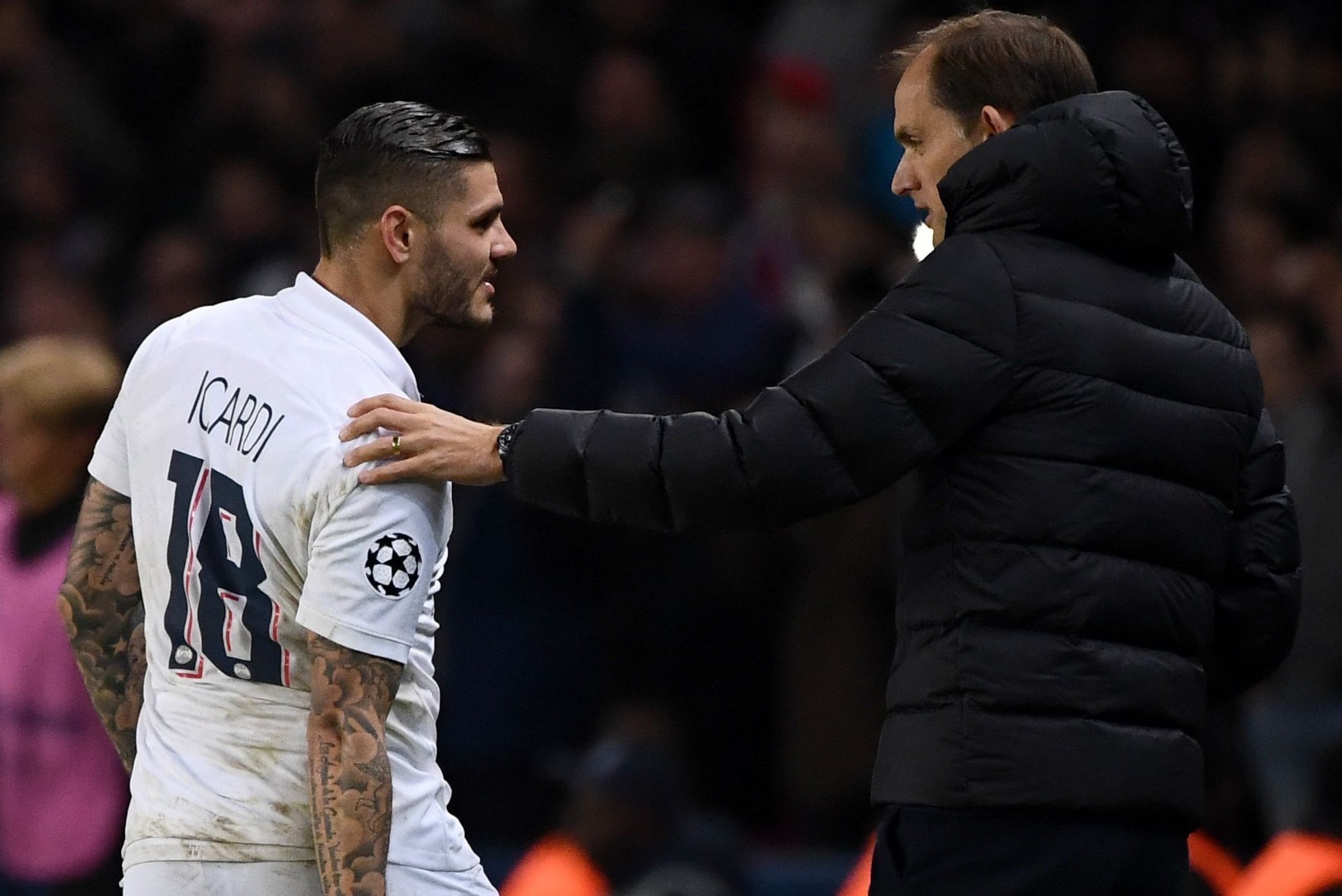 Paris Saint-Germain's Argentine forward Mauro Icardi (L) talks with Paris Saint-Germain's German coach Thomas Tuchel as he leaves the pitch during the UEFA Champions League Group A football match between Paris Saint-Germain (PSG) and Club Brugge at the Pa