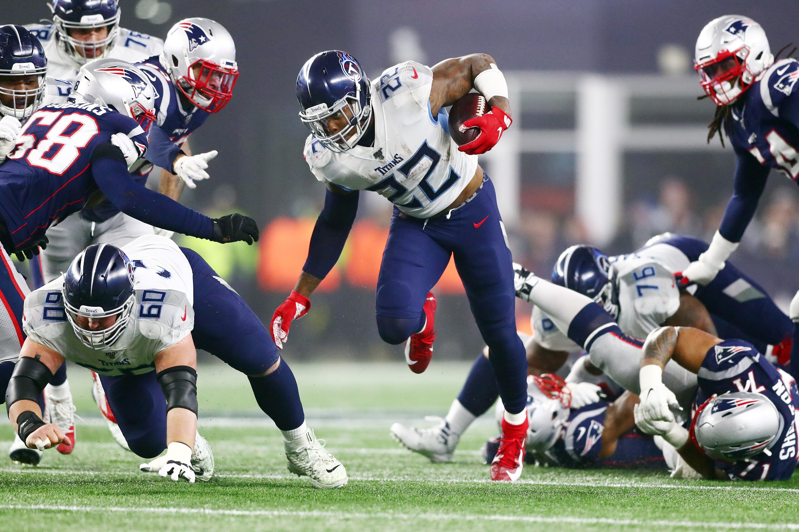 FOXBOROUGH, MASSACHUSETTS - JANUARY 04: Derrick Henry #22 of the Tennessee Titans carries the ball against the New England Patriots in the second quarter of the AFC Wild Card Playoff game at Gillette Stadium on January 04, 2020 in Foxborough, Massachusett