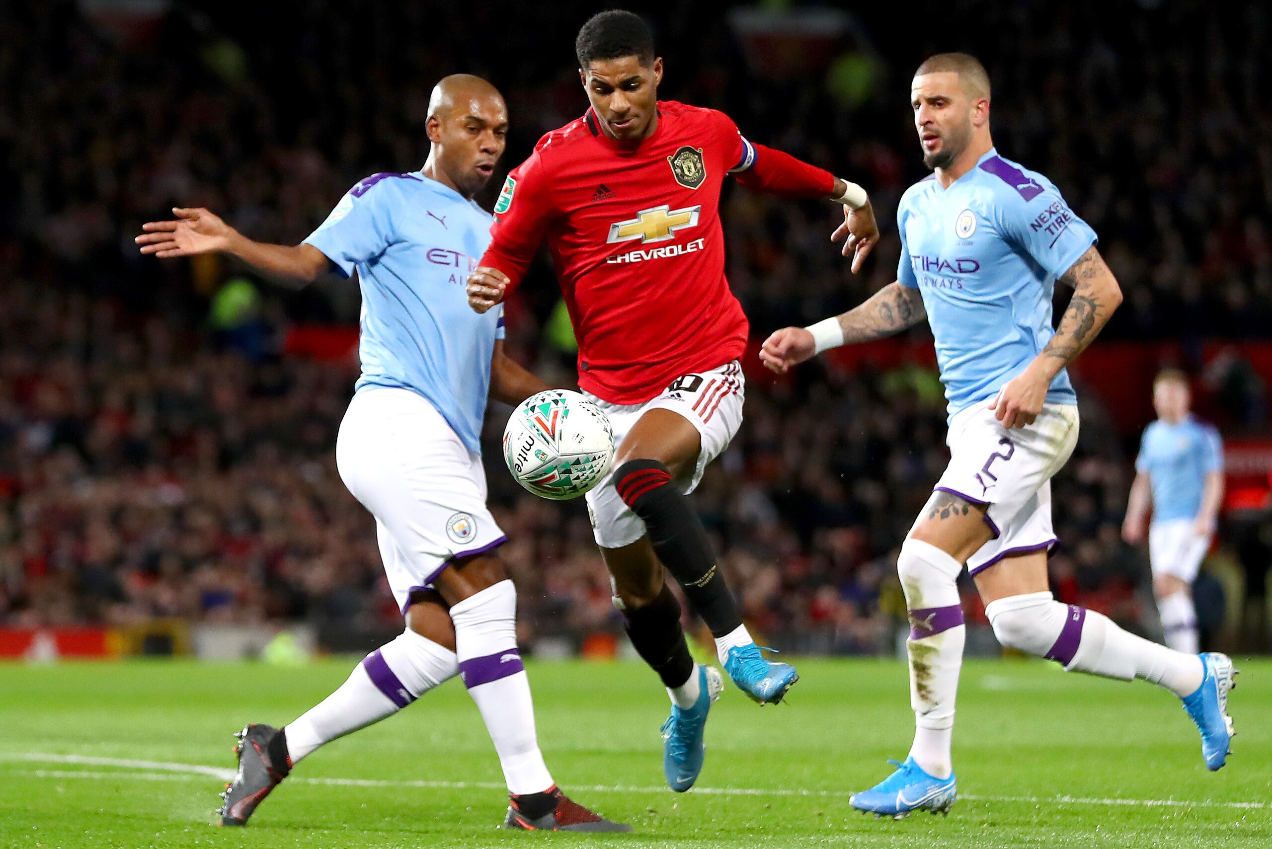 MANCHESTER, ENGLAND - JANUARY 07: Marcus Rashford of Manchester United is challenged by Fernandinho of Manchester City during the Carabao Cup Semi Final match between Manchester United and Manchester City at Old Trafford on January 07, 2020 in Manchester,