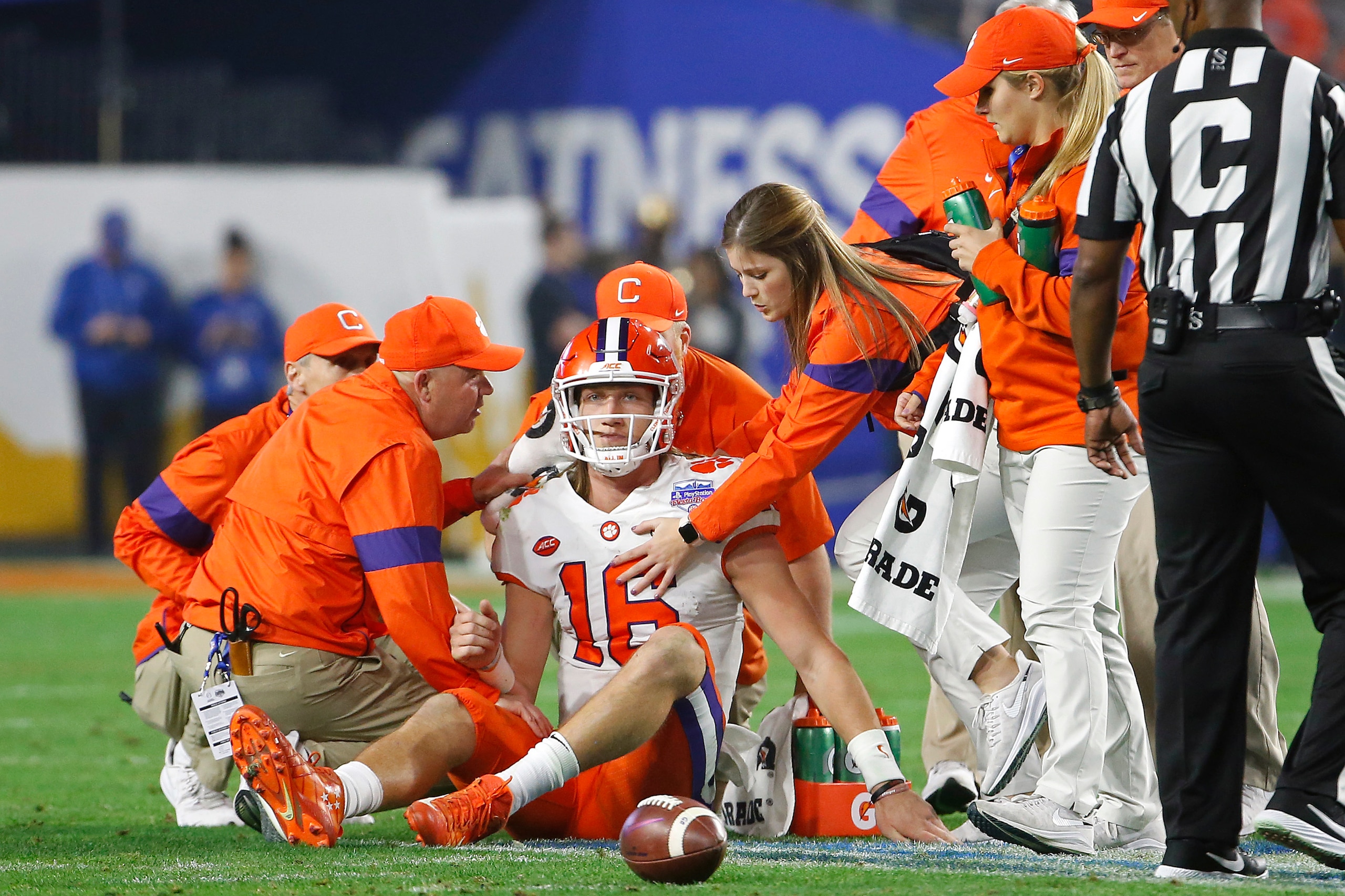 GLENDALE, ARIZONA - DECEMBER 28: Trevor Lawrence #16 of the Clemson Tigers is checked by the training staff after being hit against the Ohio State Buckeyes in the first half during the College Football Playoff Semifinal at the PlayStation Fiesta Bowl at GLENDALE, ARIZONA - DECEMBER 28: Trevor Lawrence #16 of the Clemson Tigers is checked by the training staff after being hit against the Ohio State Buckeyes in the first half during the College Football Playoff Semifinal at the PlayStation Fiesta Bowl at