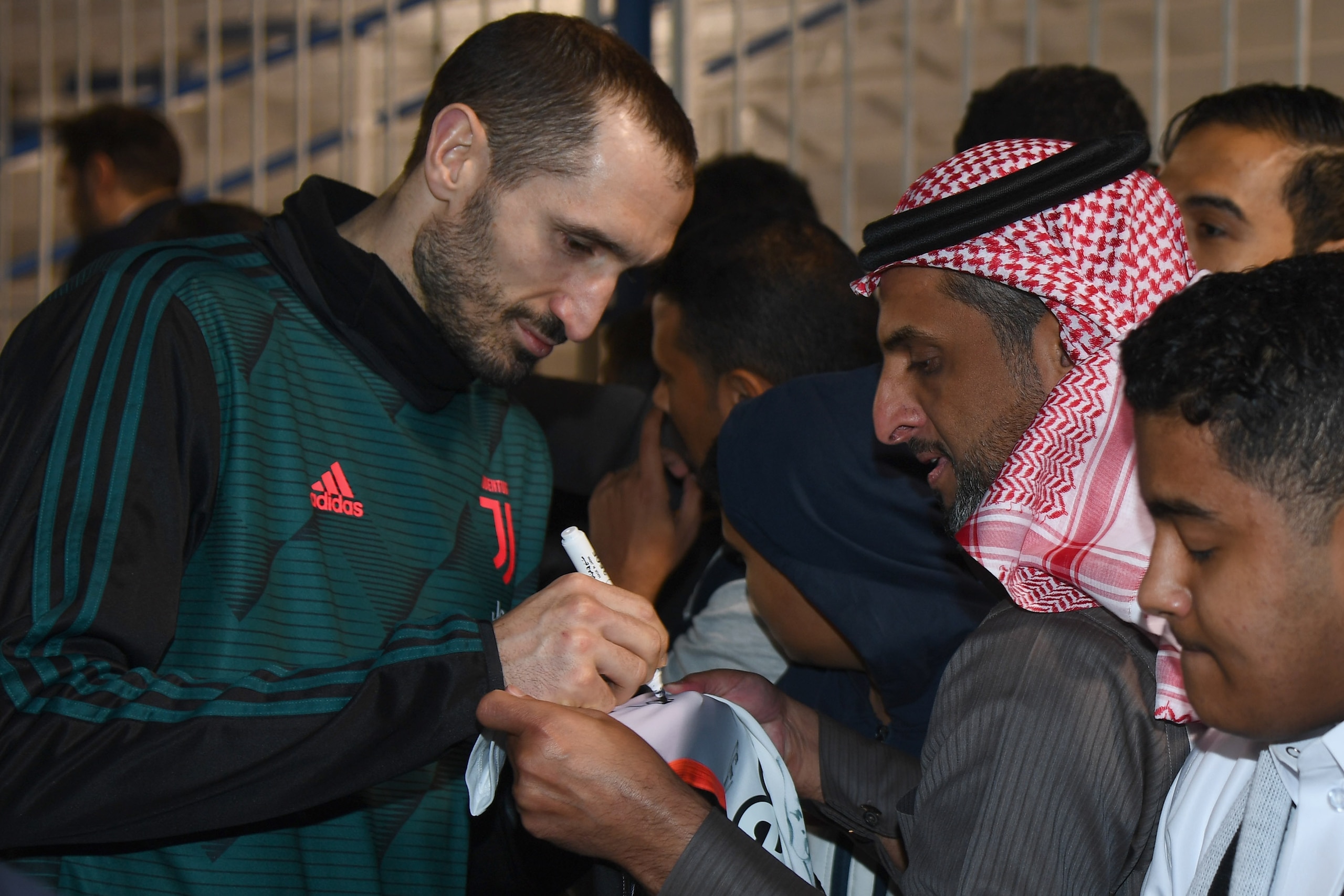 RIYADH, SAUDI ARABIA - DECEMBER 21:  Giorgio Chiellini of Juventus signing autographs and taking selfie before the training session on December 22, 2019 in Riyadh, Saudi Arabia.  (Photo by Claudio Villa/Getty Images for Lega Serie A)