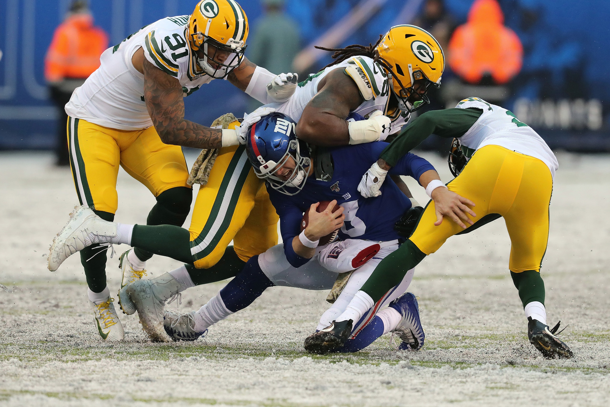 EAST RUTHERFORD, NEW JERSEY - DECEMBER 1: Cornerback Kevin King #20, Linebacker Za'Darius Smith #55 and Linebacker Preston Smith #91 of the Green Bay Packers gang tackle Quarterback Daniel Jones #8 of the New York Giants in the second half in the snow at 