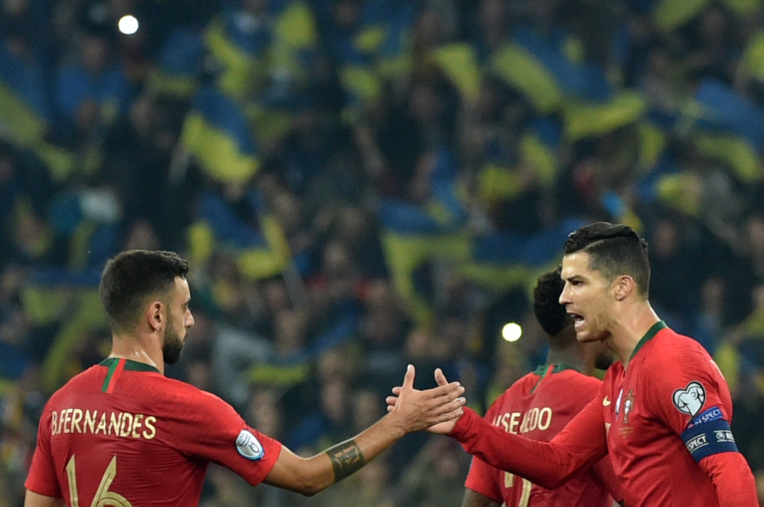 Portugal's forward Cristiano Ronaldo shakes hands with Portugal's midfielder Bruno Fernandes after the the Euro 2020 football qualification match between Ukraine and Portugal at the NSK Olimpiyskyi stadium in Kiev on October 14, 2019. (Photo by Genya SAVI Portugal's forward Cristiano Ronaldo shakes hands with Portugal's midfielder Bruno Fernandes after the the Euro 2020 football qualification match between Ukraine and Portugal at the NSK Olimpiyskyi stadium in Kiev on October 14, 2019. (Photo by Genya SAVI