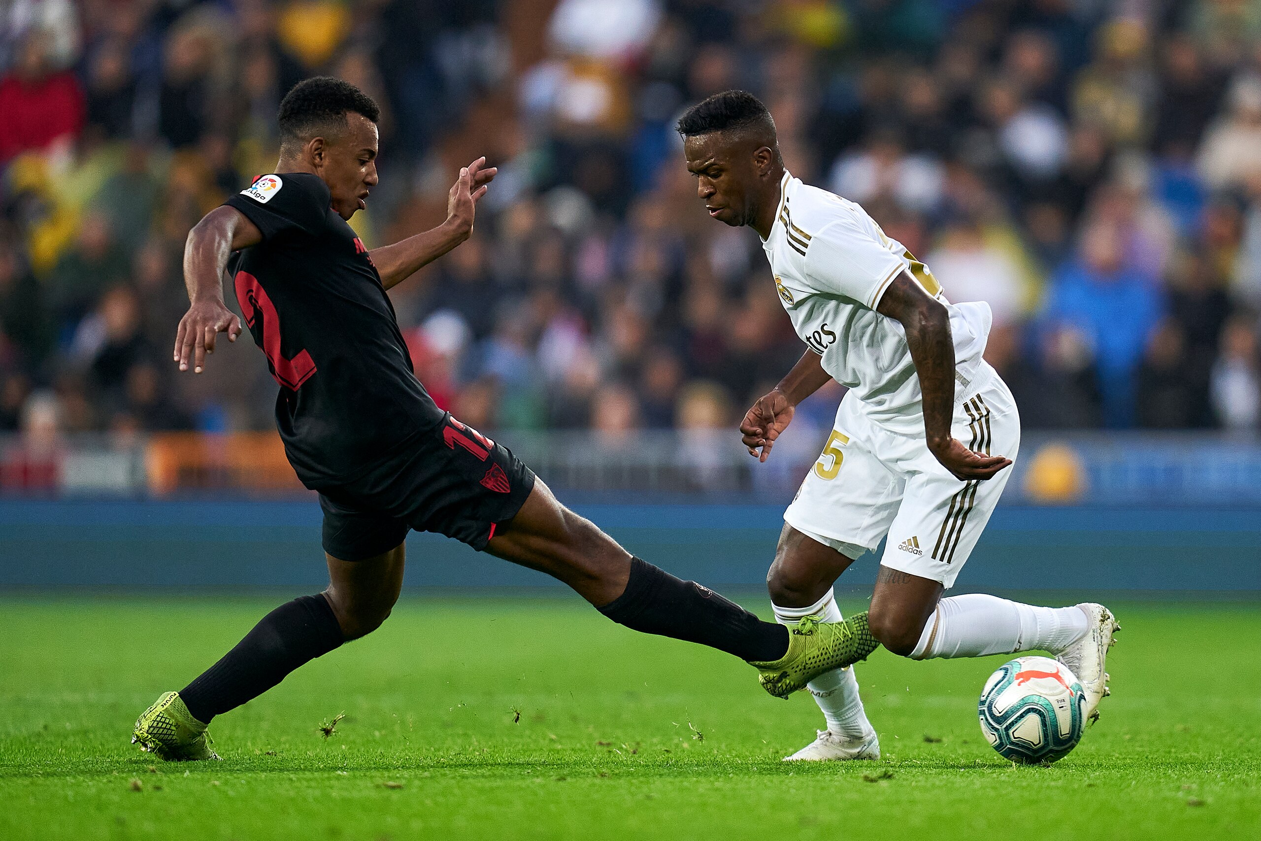 MADRID, SPAIN - JANUARY 18: Vinicius Jr of Real Madrid CF battle for the ball with Jules Kounde of Sevilla FC during the Liga match between Real Madrid CF and Sevilla FC at Estadio Santiago Bernabeu on January 18, 2020 in Madrid, Spain. (Photo by Quality 