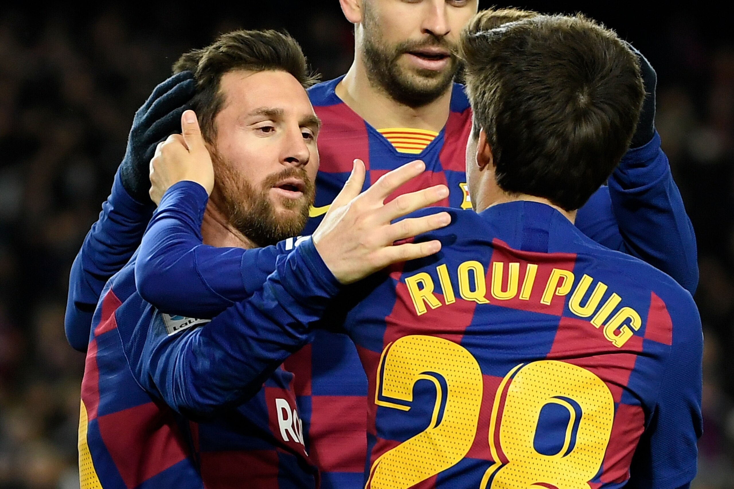 Barcelona's Argentine forward Lionel Messi (L) is congratulated by Barcelona's Spanish midfielder Riqui Puig after scoring the opening goal during the Spanish league football match between FC Barcelona and Granada FC at the Camp Nou stadium in Barcelona o
