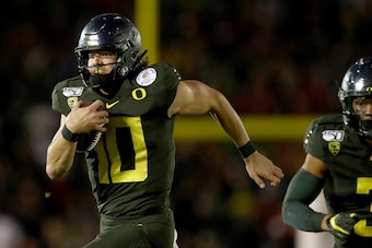 PASADENA, CALIFORNIA - JANUARY 01: Justin Herbert #10 of the Oregon Ducks runs with the ball to score a 30 yard touchdown against the Wisconsin Badgers during the fourth quarter in the Rose Bowl game presented by Northwestern Mutual at Rose Bowl on Januar