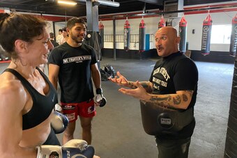 UFC flyweight contender Lauren Murphy and MMA fighter Paul Garza receive instruction from Bob Perez.