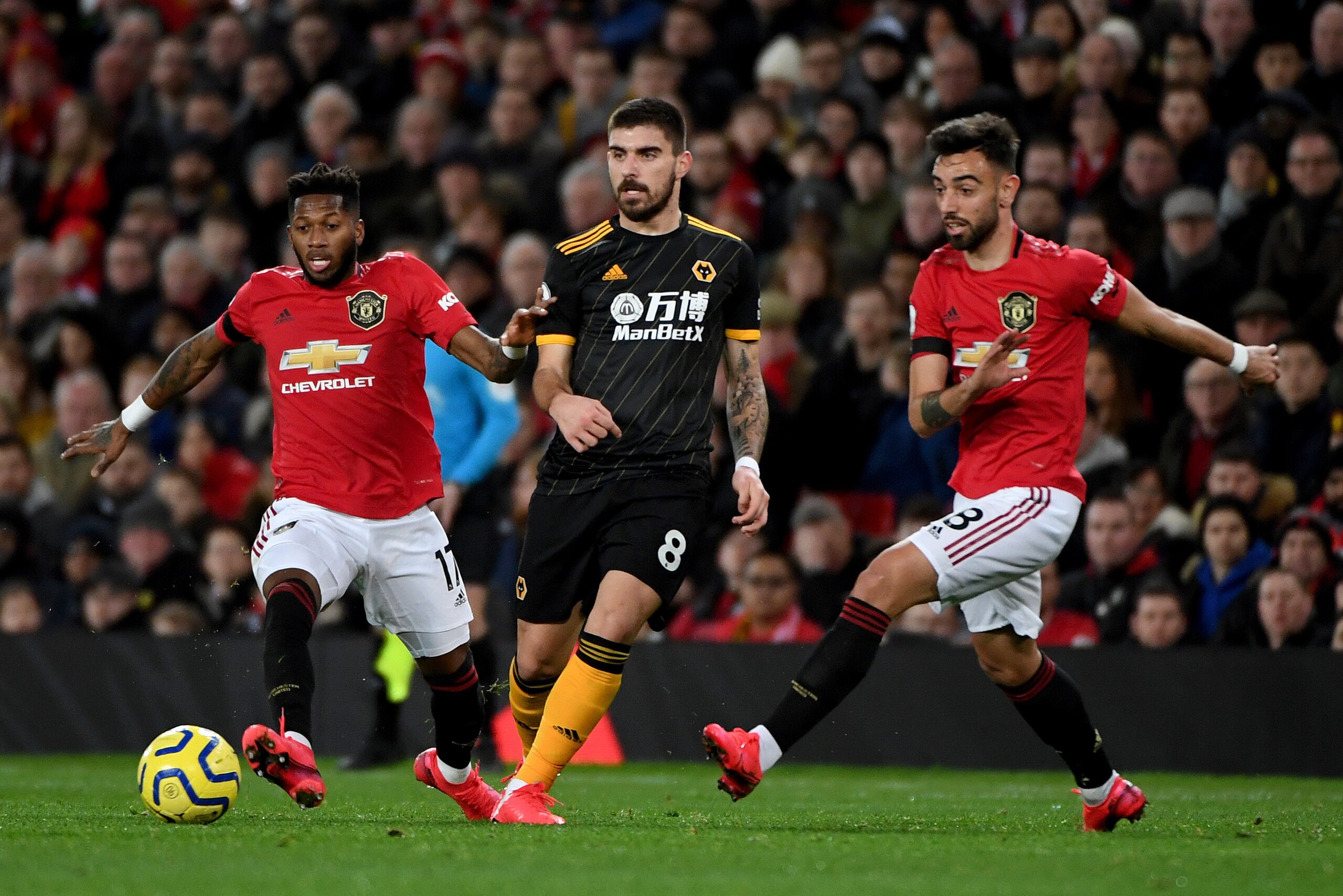 MANCHESTER, ENGLAND - FEBRUARY 01: Fred of Manchester United, Ruben Neves of Wolverhampton Wanderers and Bruno Fernandes of Manchester United during the Premier League match between Manchester United and Wolverhampton Wanderers at Old Trafford on February