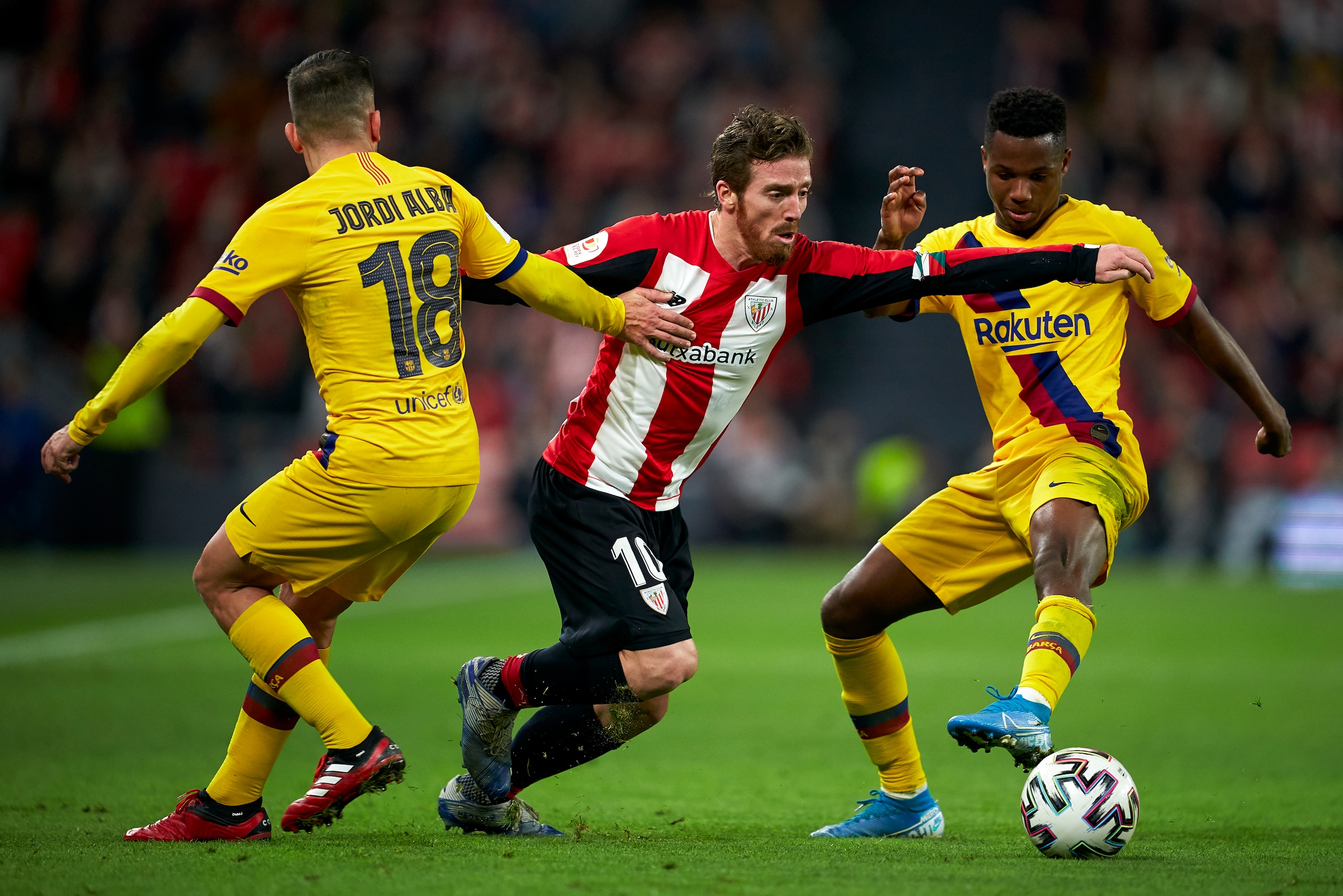 BILBAO, SPAIN - FEBRUARY 06: Iker Muniain of Athletic Club competes for the ball with Ansu Fati of FC Barcelona and Jordi Alba of FC Barcelona during the Copa del Rey Quarter Final match between Athletic Club de Bilbao and FC Barcelona at Estadio de San M