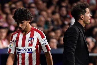 Atletico Madrid's Portuguese midfielder Joao Felix (L) walks past Atletico Madrid's Argentinian coach Diego Simeone as he leaves the pitch after getting injured during the Spanish League football match between Atletico Madrid and Getafe at the Wanda Metro
