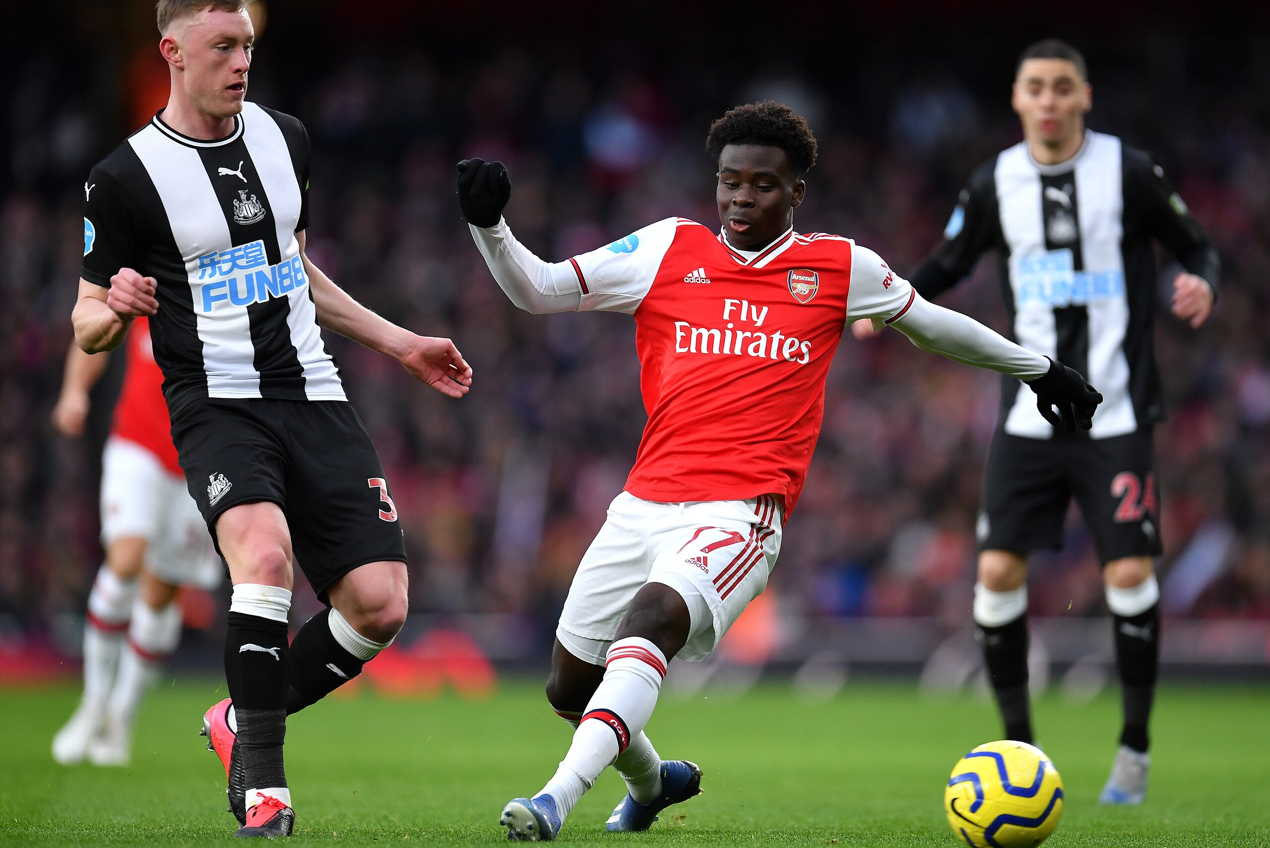 LONDON, ENGLAND - FEBRUARY 16: Bukayo Saka of Arsenal is closed down by Sean Longstaff of Newcastle United during the Premier League match between Arsenal FC and Newcastle United at Emirates Stadium on February 16, 2020 in London, United Kingdom. (Photo b