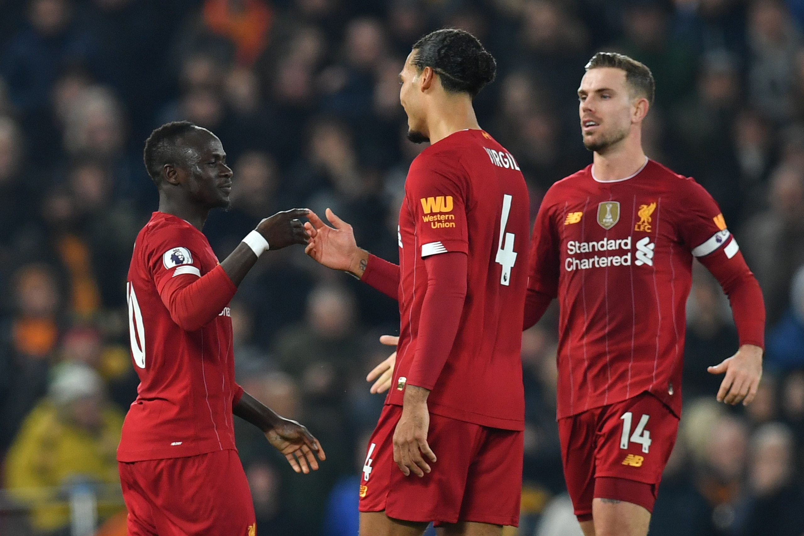 Liverpool's Senegalese striker Sadio Mane (L) celebrates with Liverpool's Dutch defender Virgil van Dijk (C) and Liverpool's English midfielder Jordan Henderson (R) after scoring the opening goal during the English Premier League football match between Li