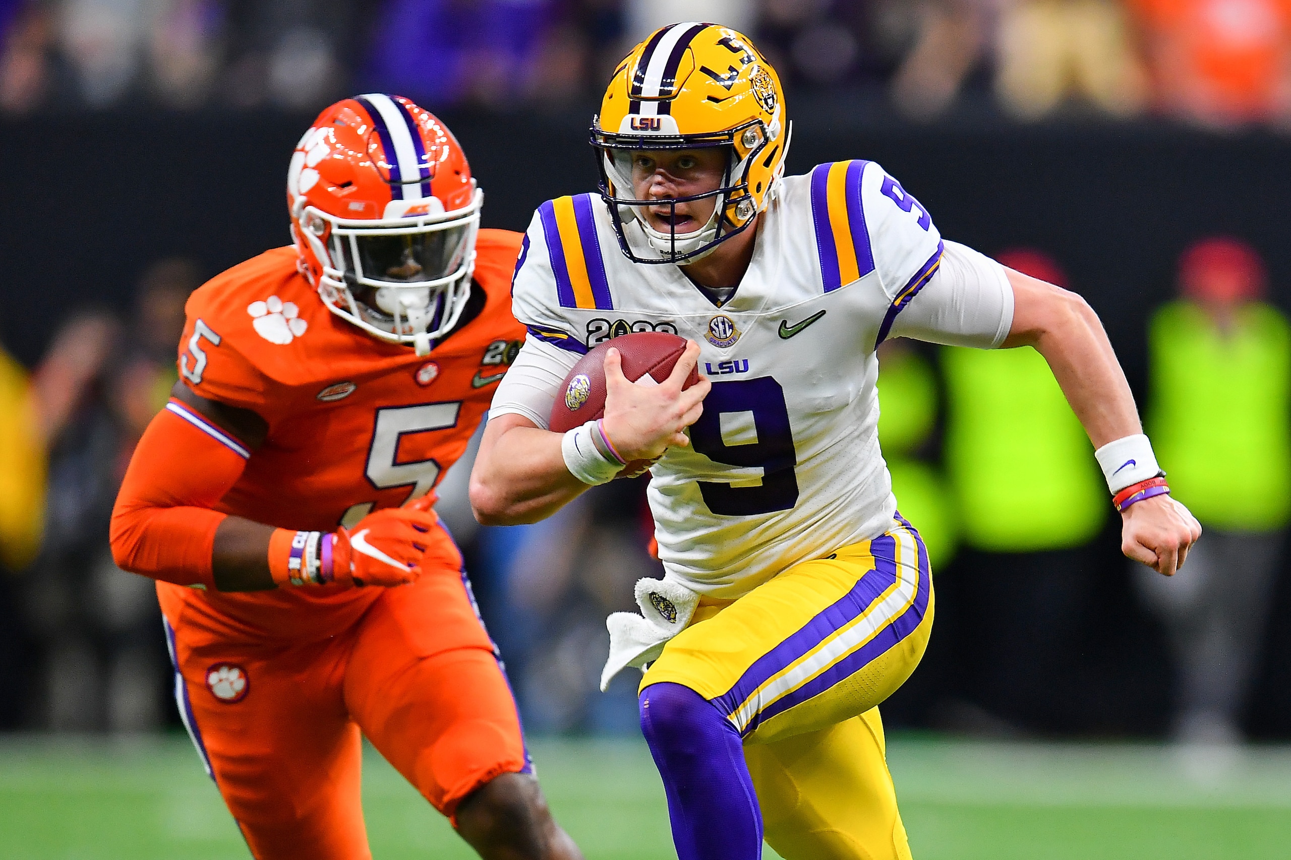 NEW ORLEANS, LOUISIANA - JANUARY 13: With the help of down field blockers, Joe Burrow #9 of the LSU Tigers, breaks free for a 29-yard run during the second quarter of the College Football Playoff National Championship game at the Mercedes Benz Superdome NEW ORLEANS, LOUISIANA - JANUARY 13: With the help of down field blockers, Joe Burrow #9 of the LSU Tigers, breaks free for a 29-yard run during the second quarter of the College Football Playoff National Championship game at the Mercedes Benz Superdome