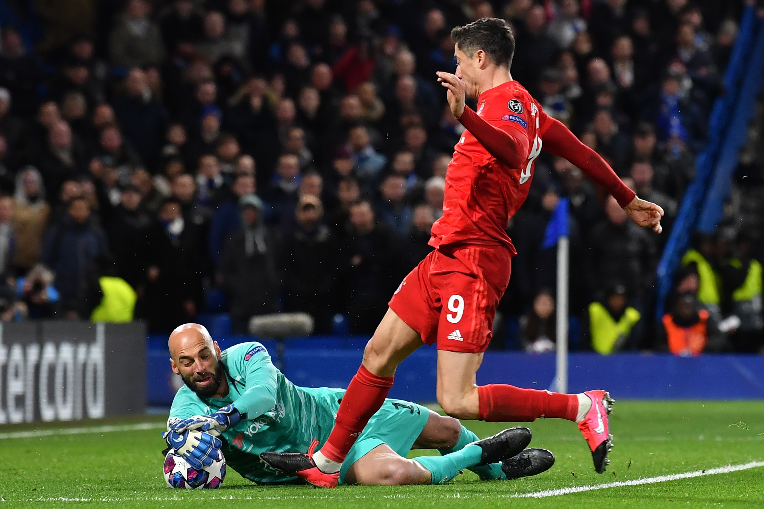 Chelsea's Argentinian goalkeeper Willy Caballero (L) saves at the feet of Bayern Munich's Polish striker Robert Lewandowski (R) during the UEFA Champion's League round of 16 first leg football match between Chelsea and Bayern Munich at Stamford Bridge in 